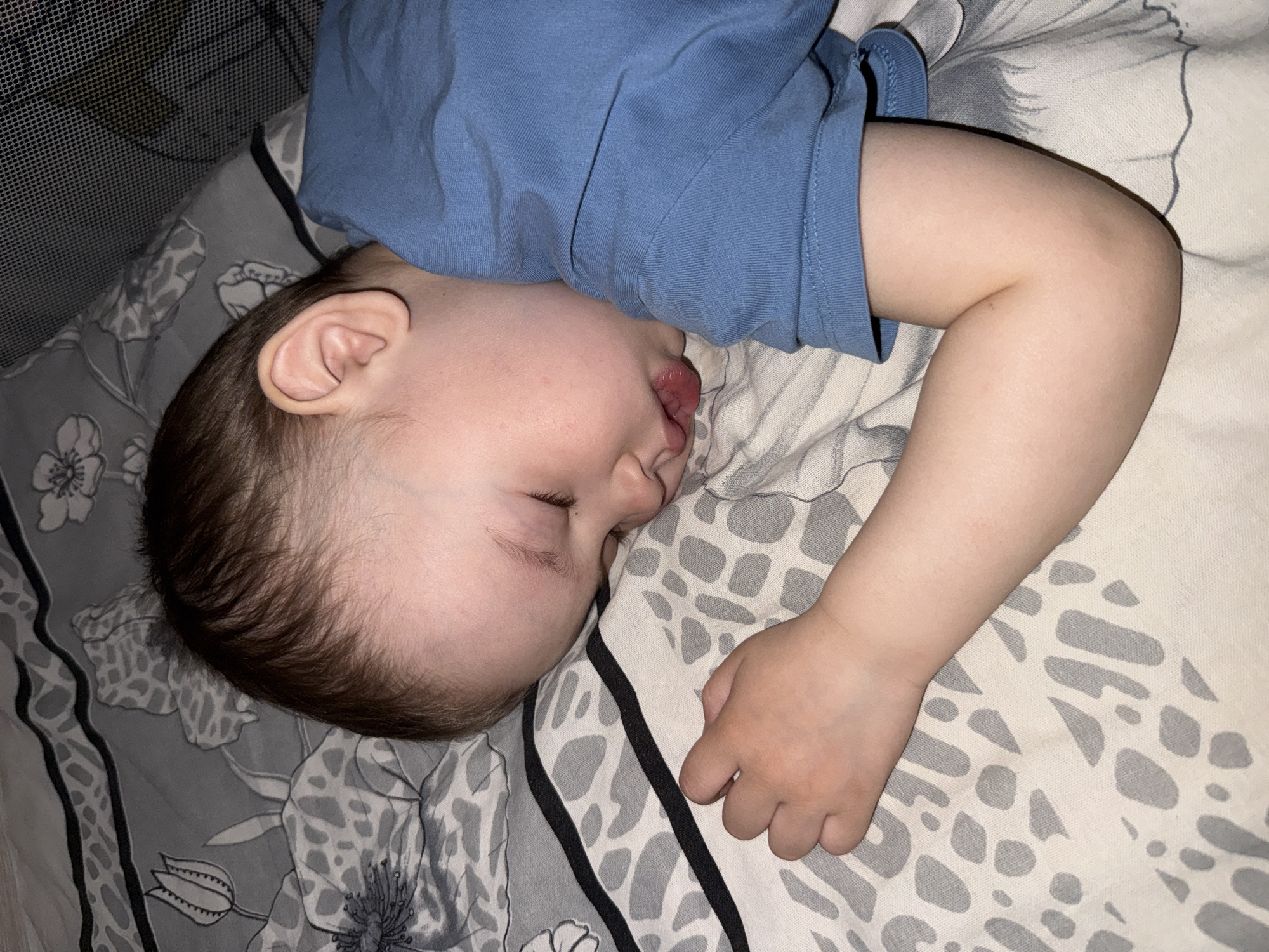 Toddler sleeps peacefully on patterned bedding in Yaroslavl