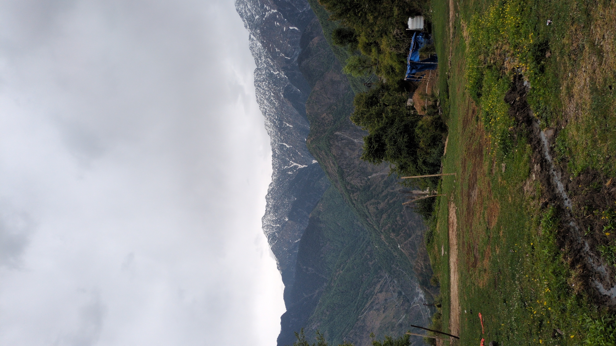 Tourist documents scenic mountain village views in Naddi, India