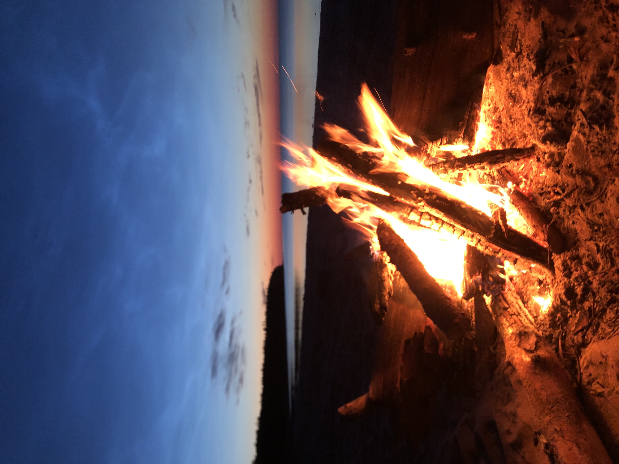 Beach bonfire at dusk on a Russian lakeshore