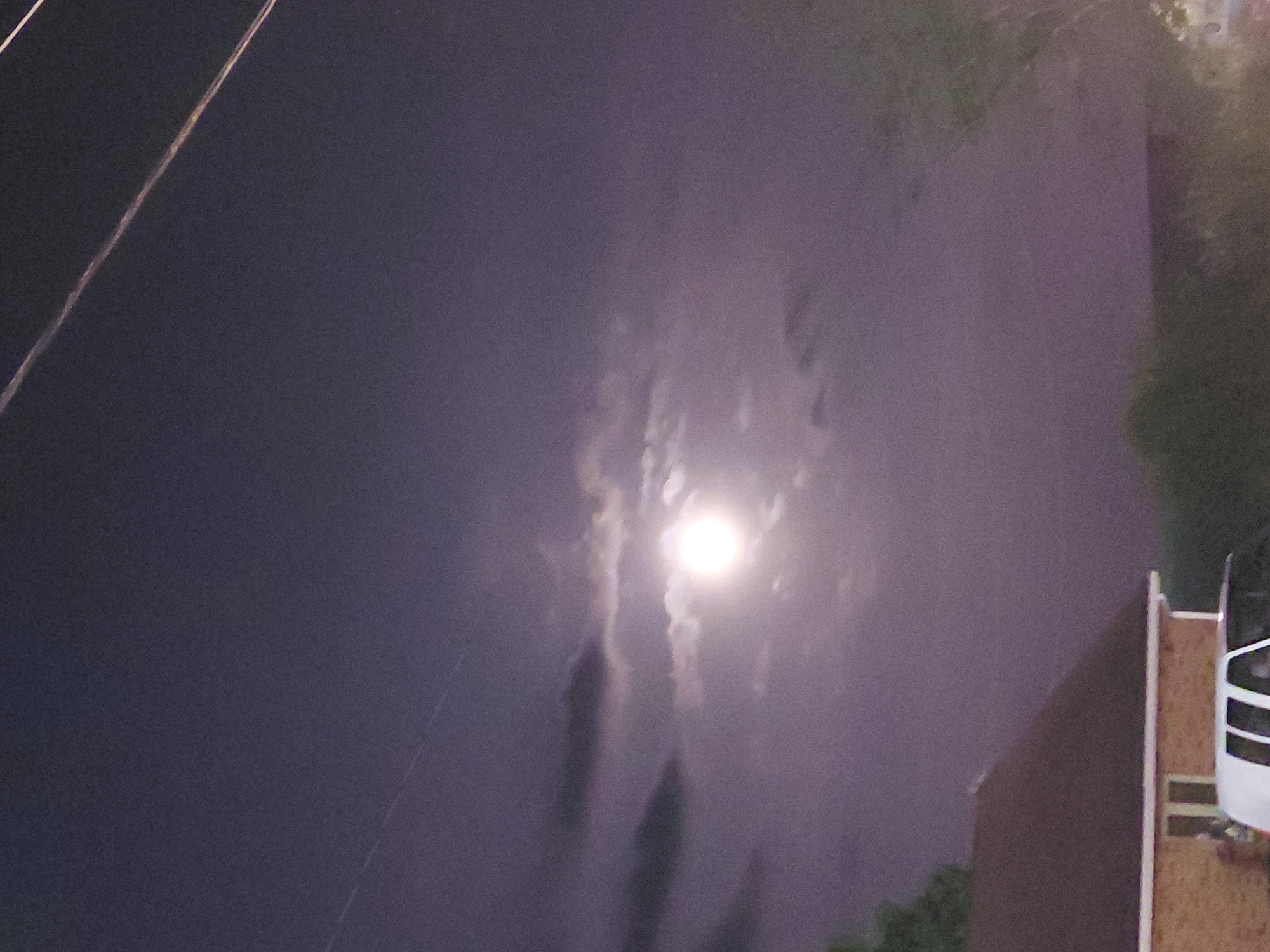 Full moon rising over Nicholasville, partly veiled by clouds
