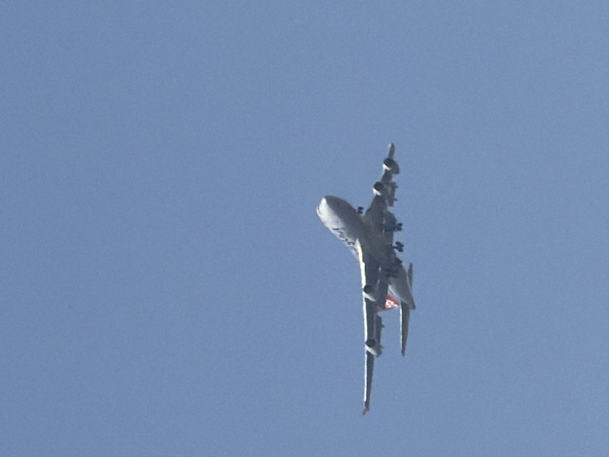 White jet on descent through clear skies over Luxembourg