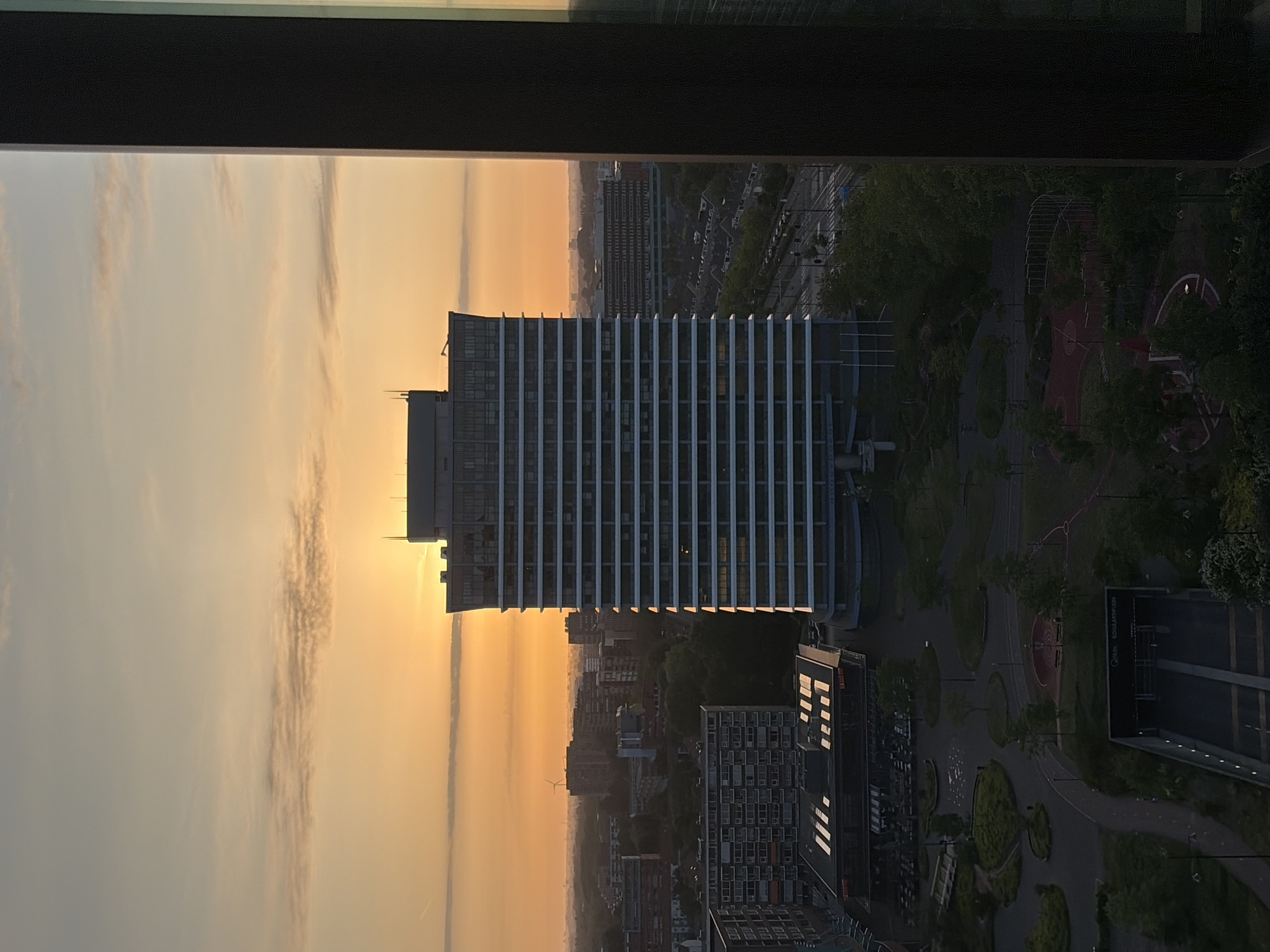 Sunrise captured over Rijswijk skyline from elevated window view