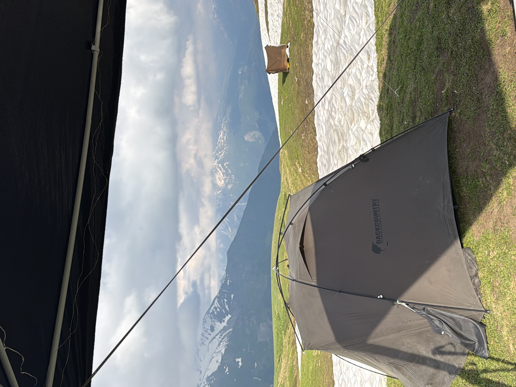 Backcountry camp in Mestia with skewers, snow, and mountain skies