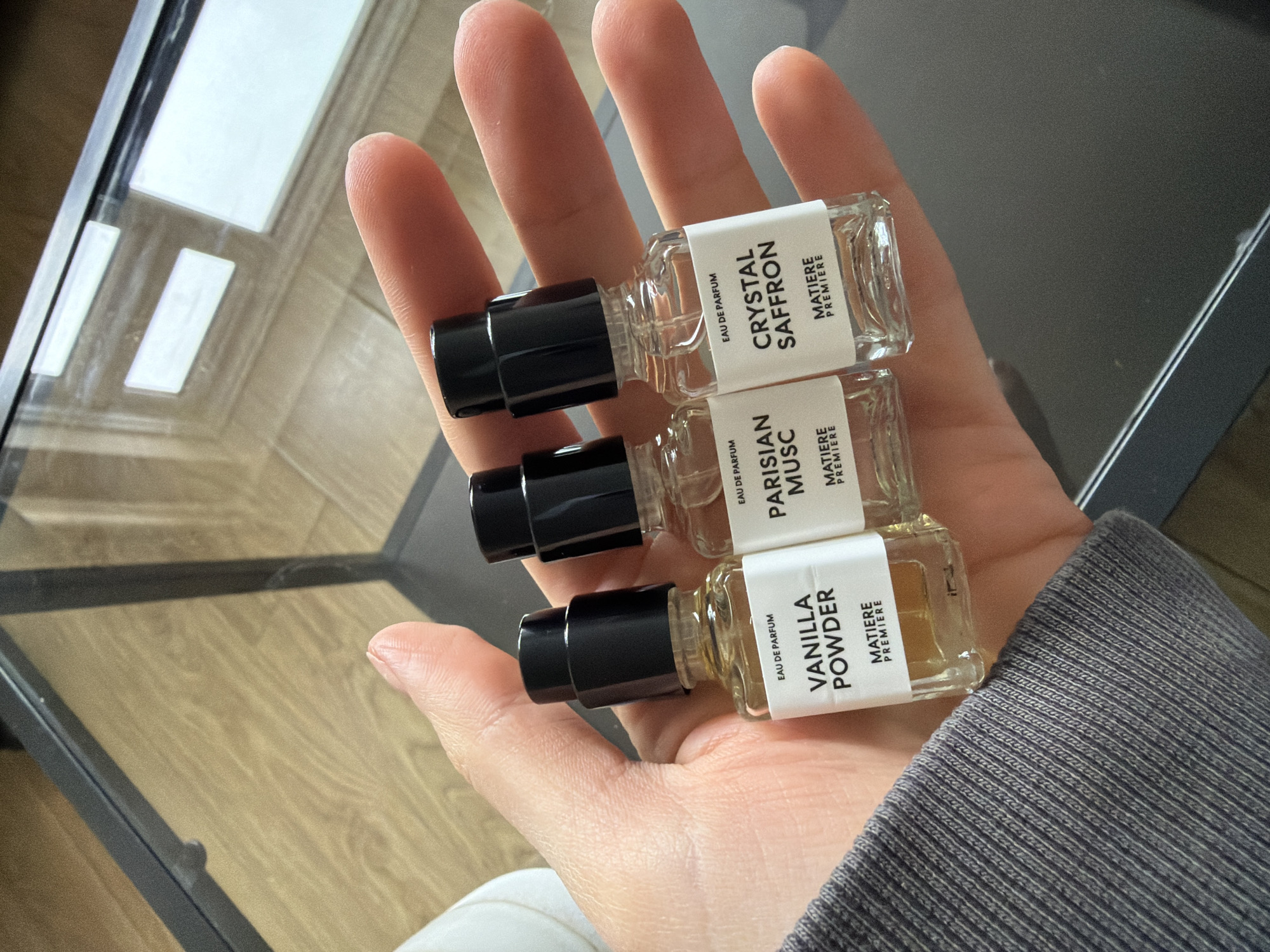 Person displays three glass perfume bottles in London