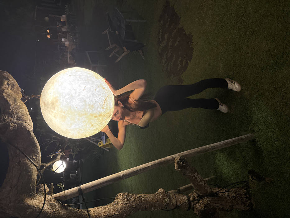 Woman interacts with illuminated sphere lamp in Indonesian city