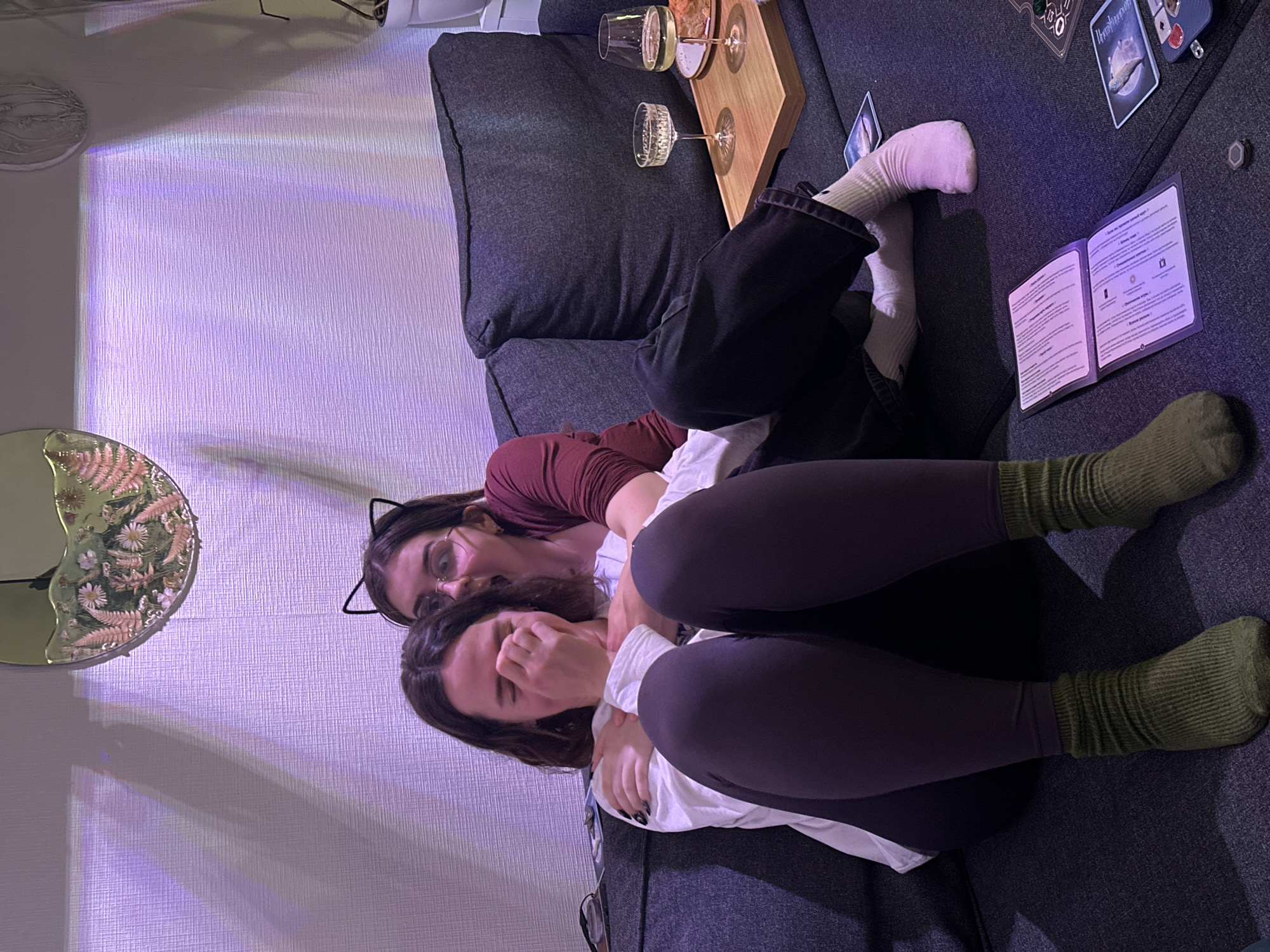 Two people relax on sofa in plant-filled home