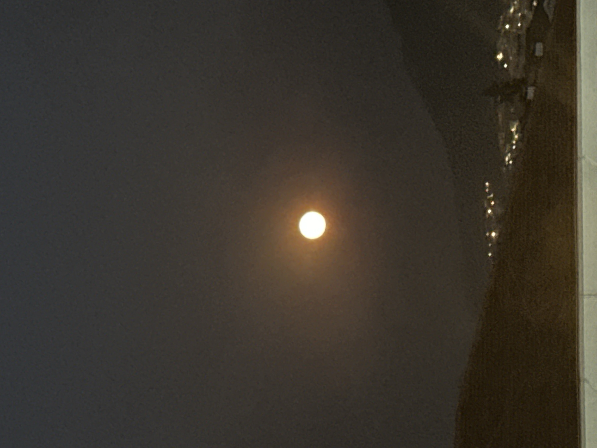 Full moon rising over Fethiye buildings at night