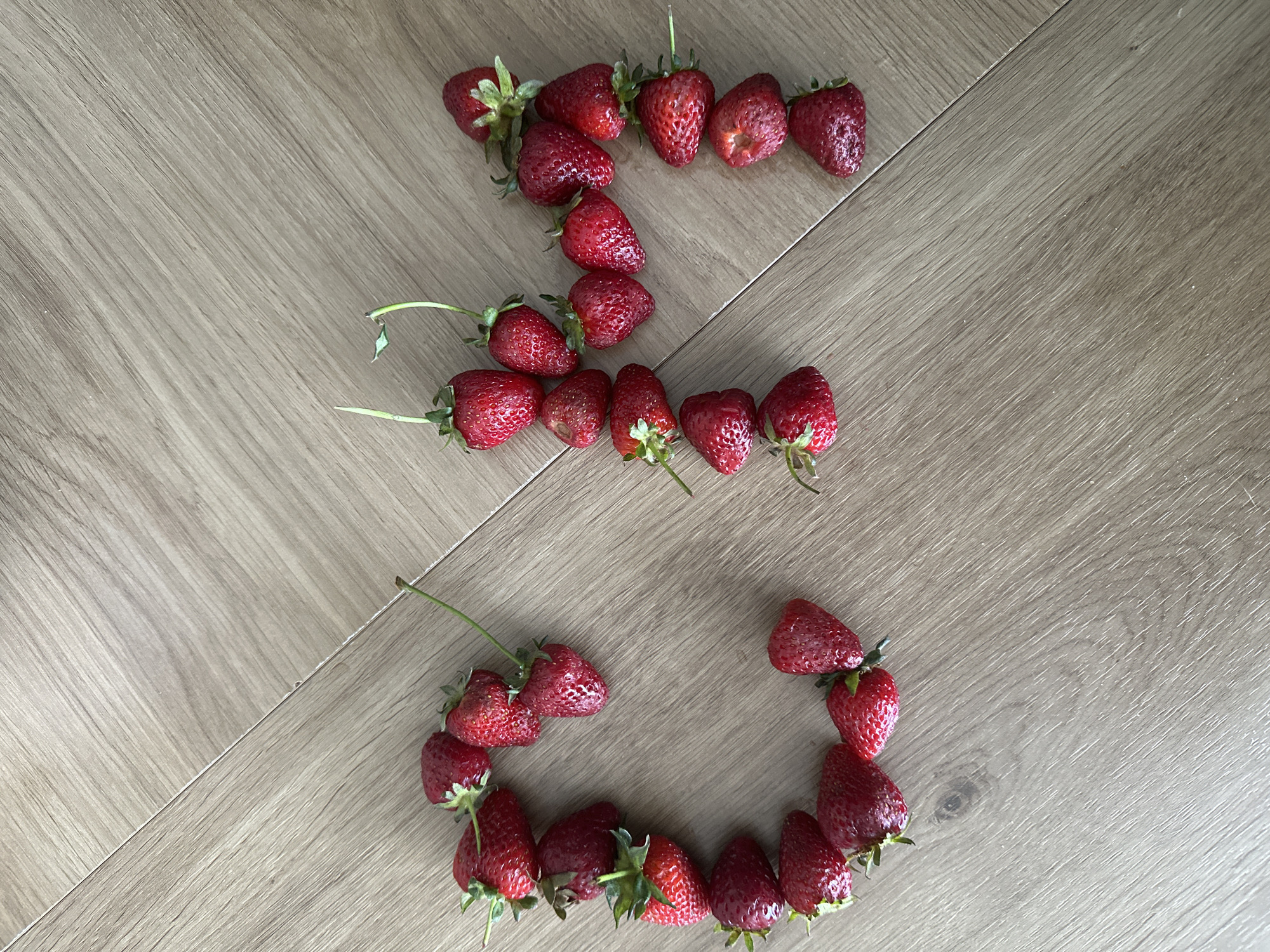 Berry art arrangement spells out messages on wooden floor