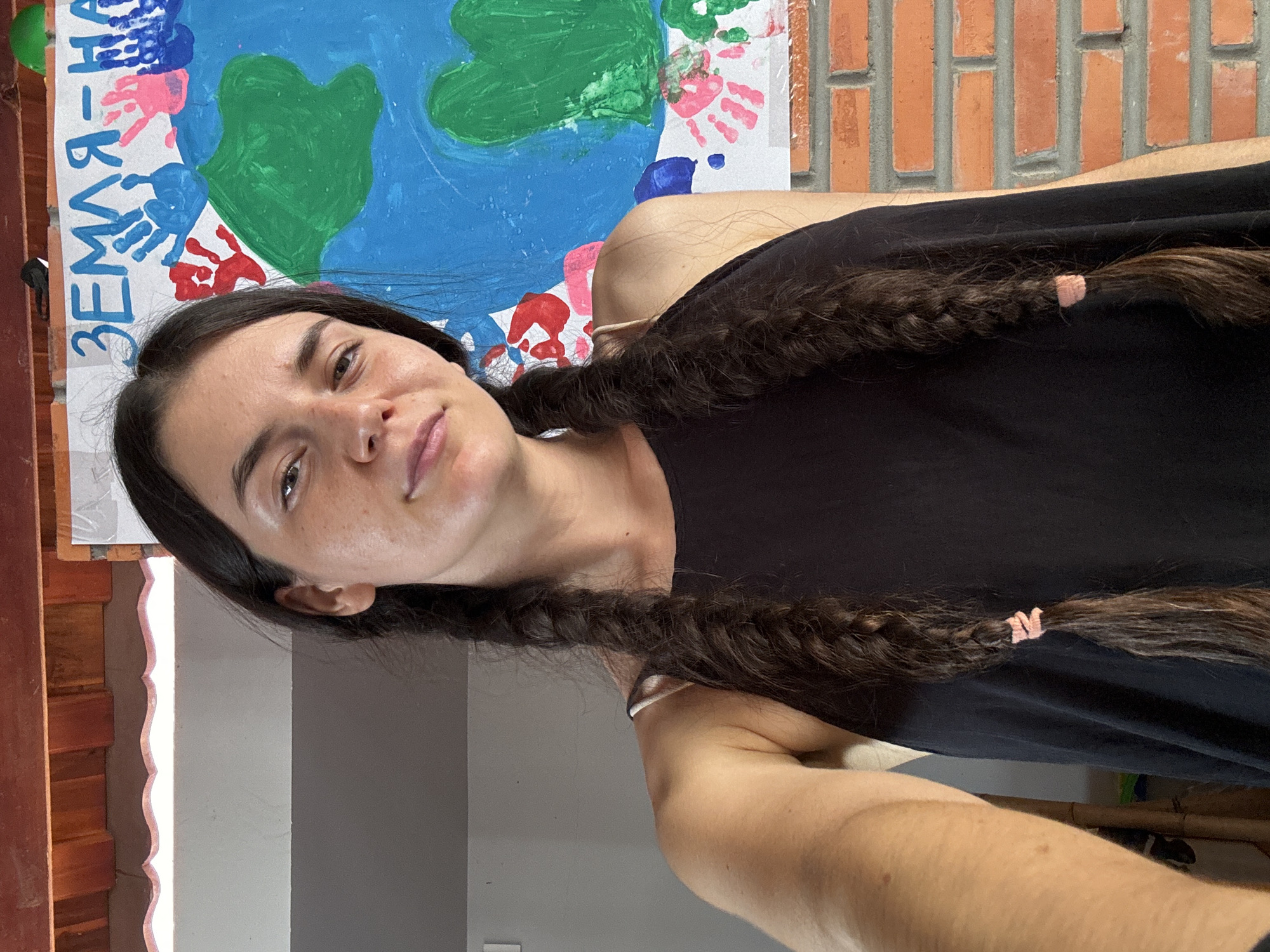 Person with braids photographed near banner in Mũi Né