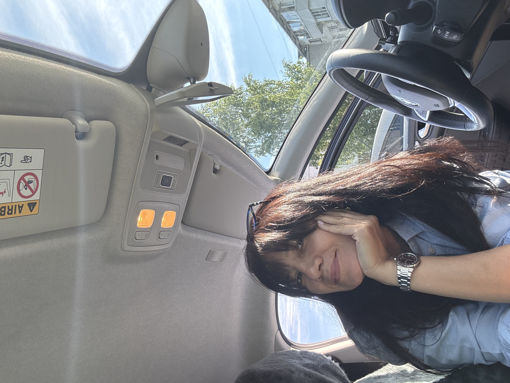 Woman photographed smiling in car during sunny day in Chaikovsky