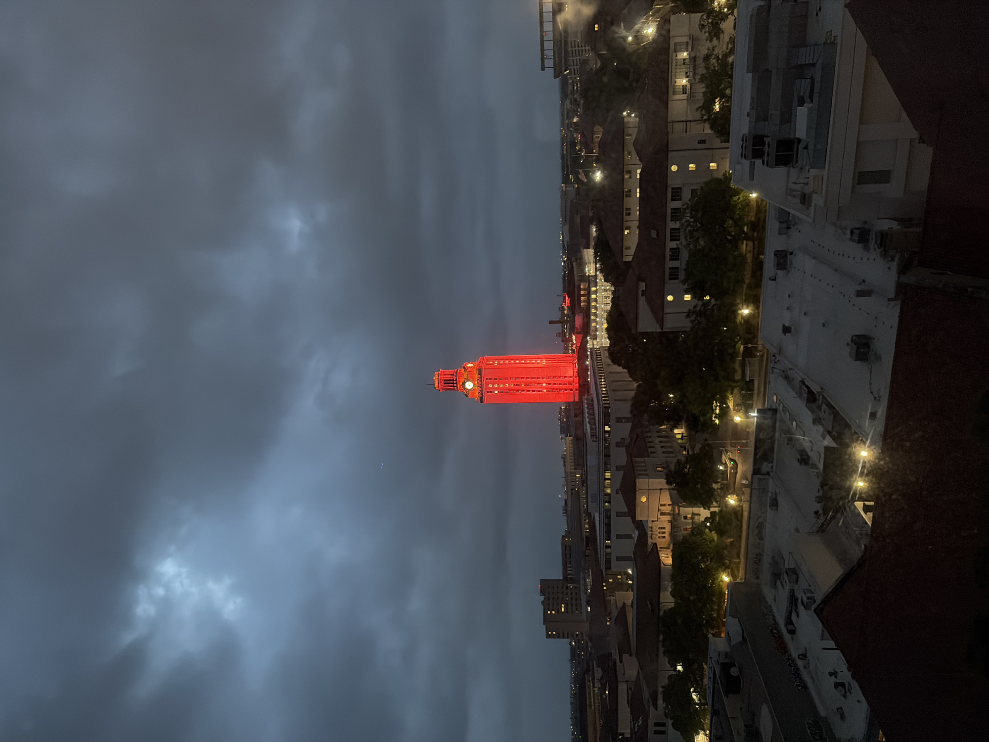 UT Tower glows red in Austin nighttime aerial view