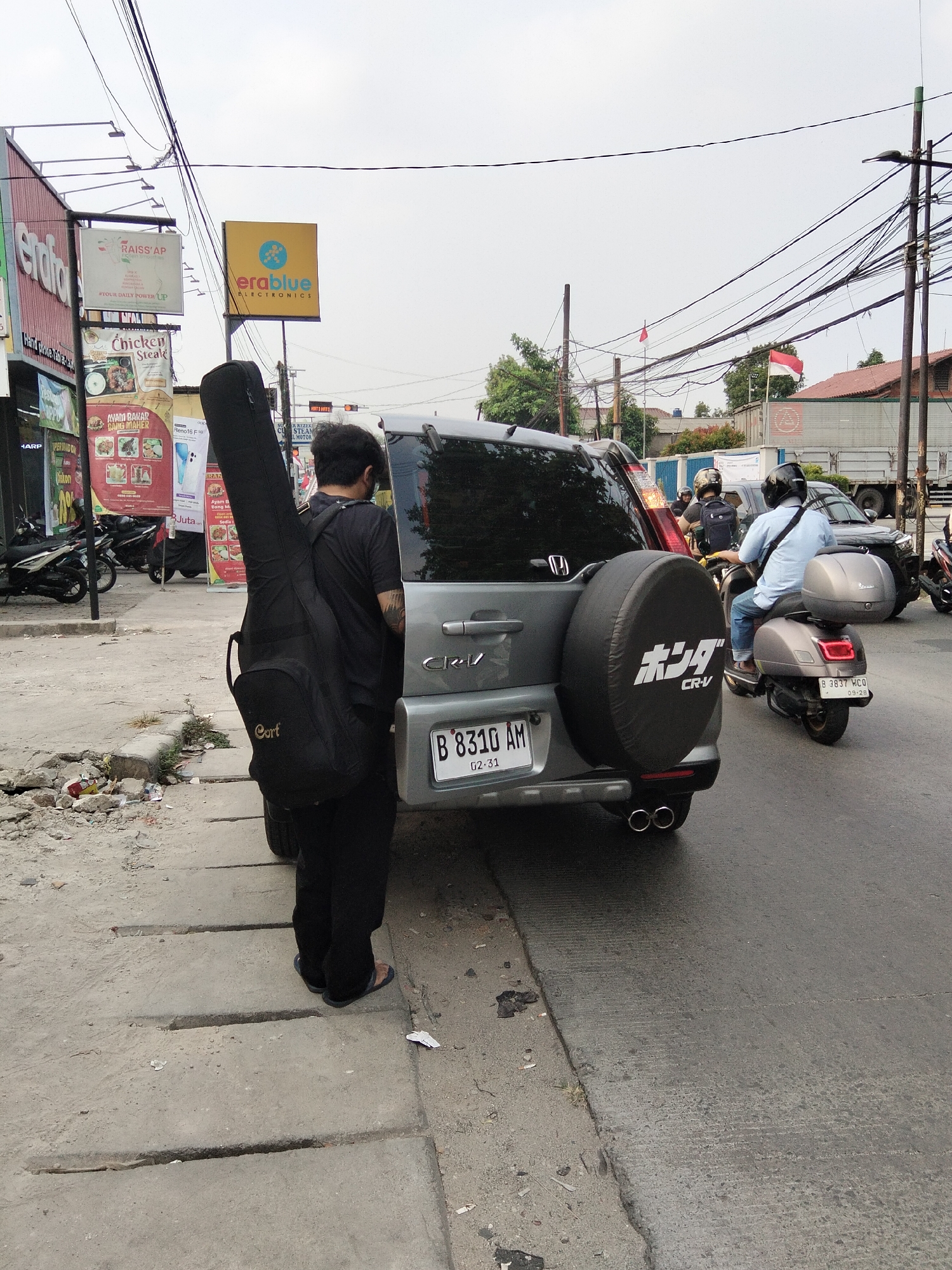 Busy South Tangerang street morning — bikes, vendors, and curb painters