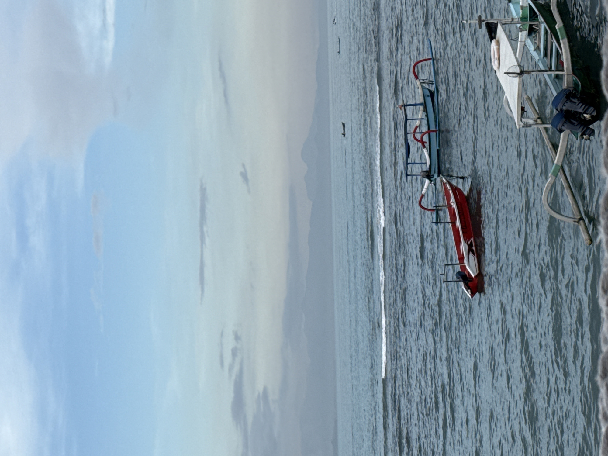 Overcast seascape with boats observed near Denpasar, Indonesia