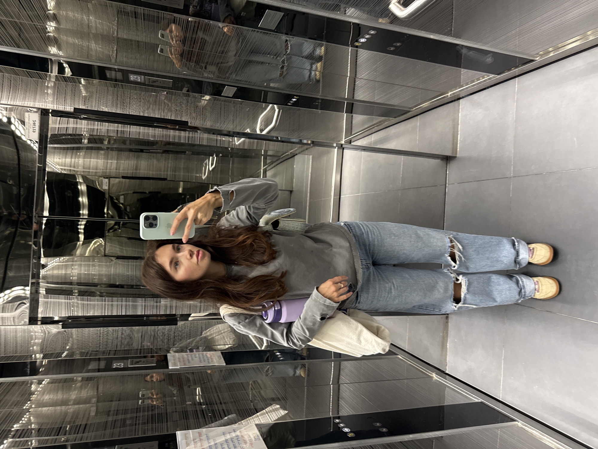 Woman takes selfie in mirrored elevator in Tel-Aviv