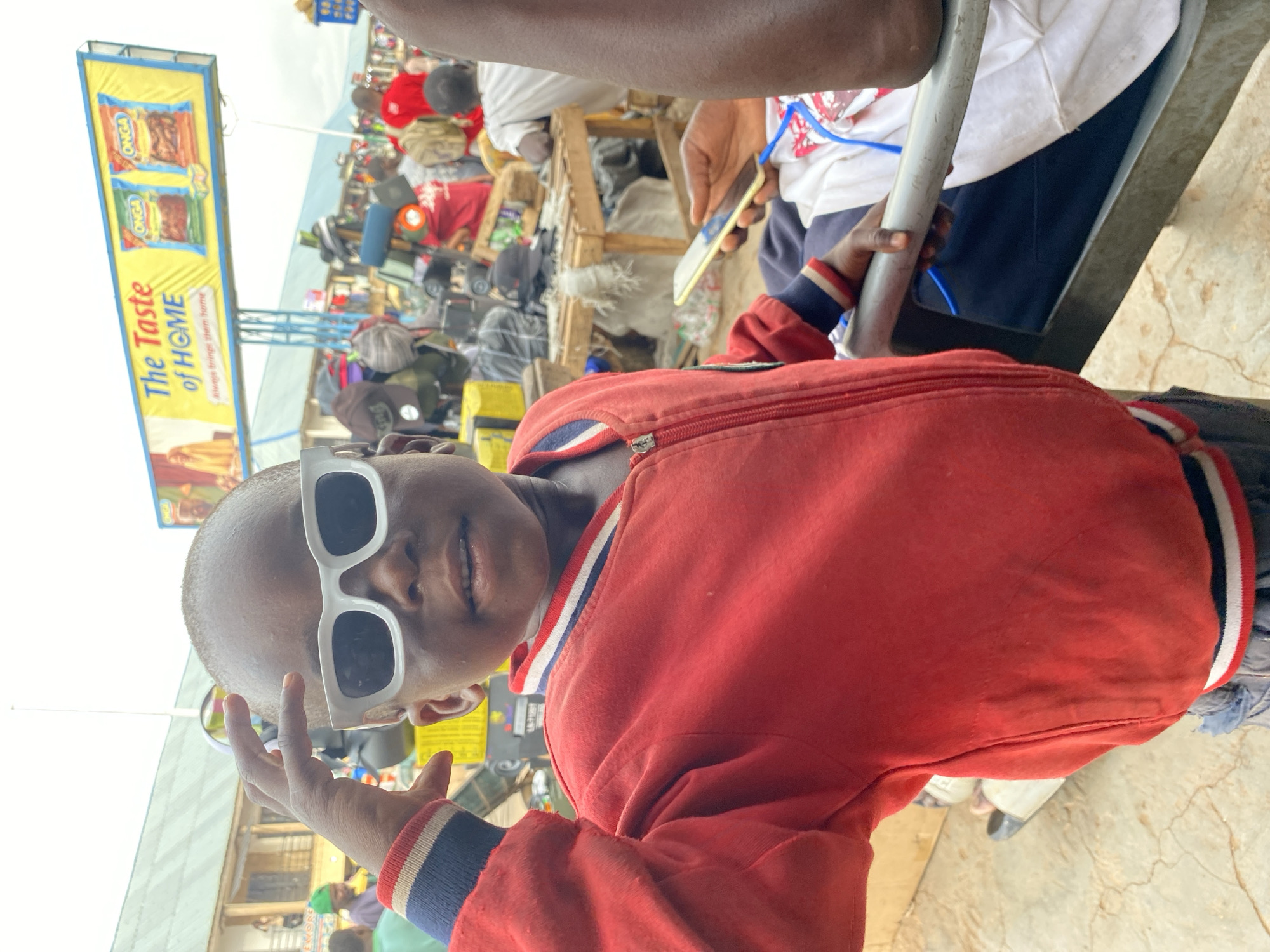 Child in sunglasses photographed at Bukuru street market