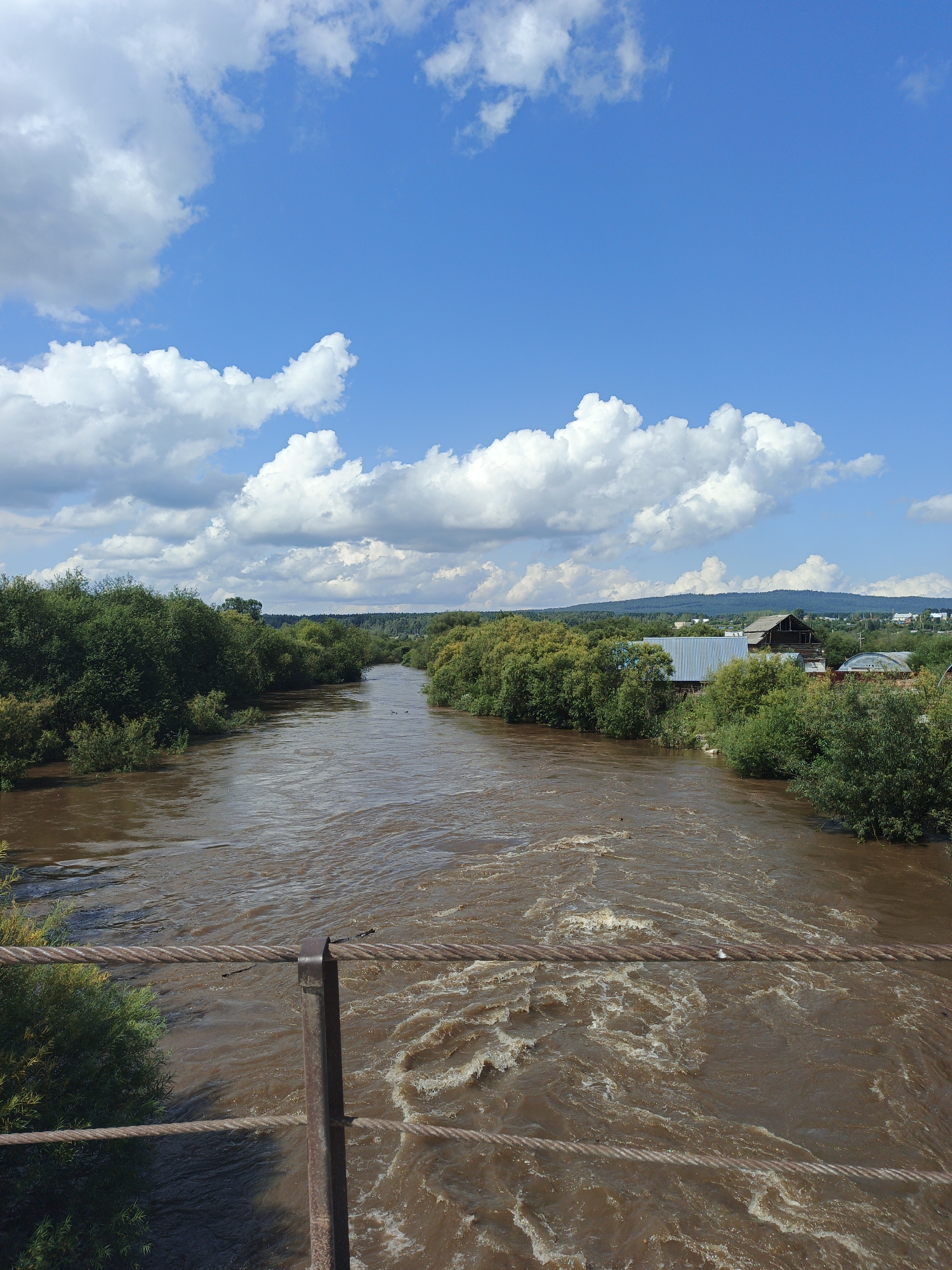Muddy river and log construction in rural Medvedyovka, Russia