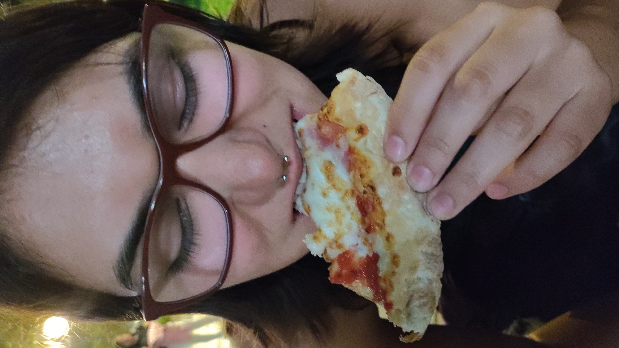 Woman eats pizza late night in Barranco, Peru