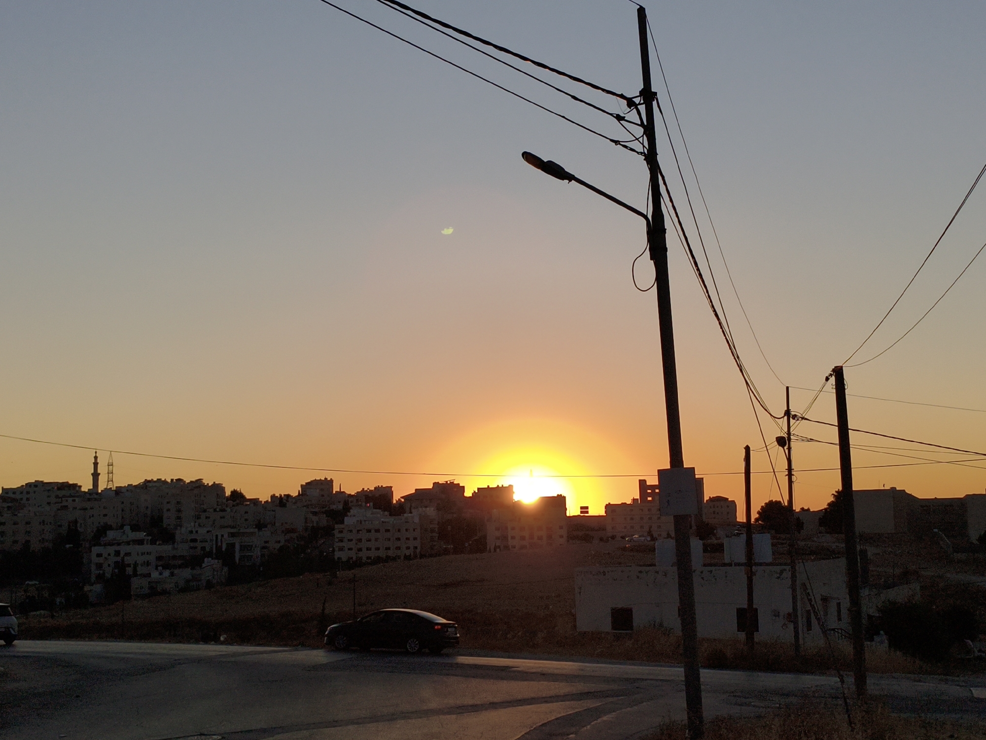 Amman skyline cuts a silhouette against a fiery sunset