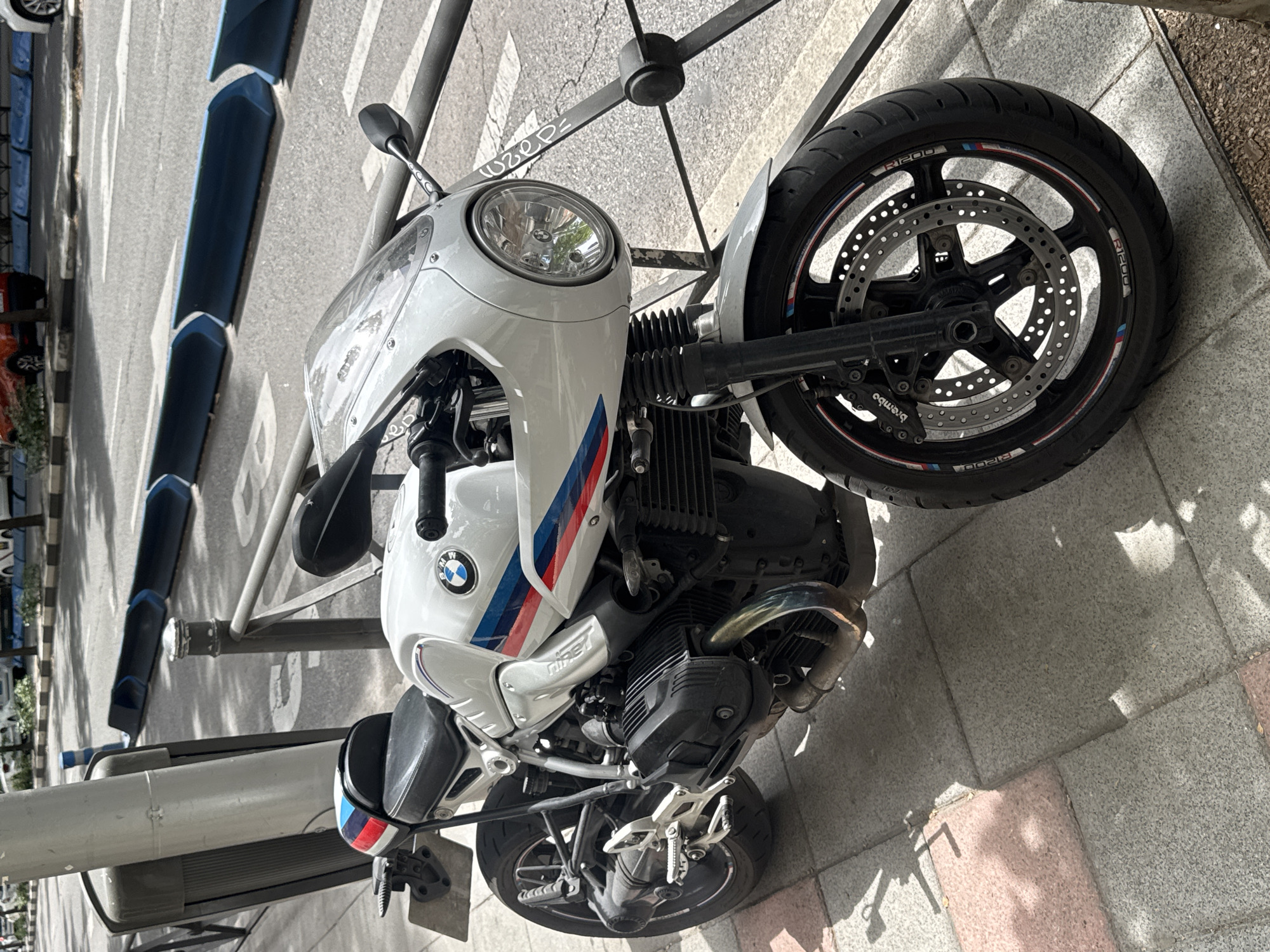 Motorcycles and scooters parked along a Madrid sidewalk
