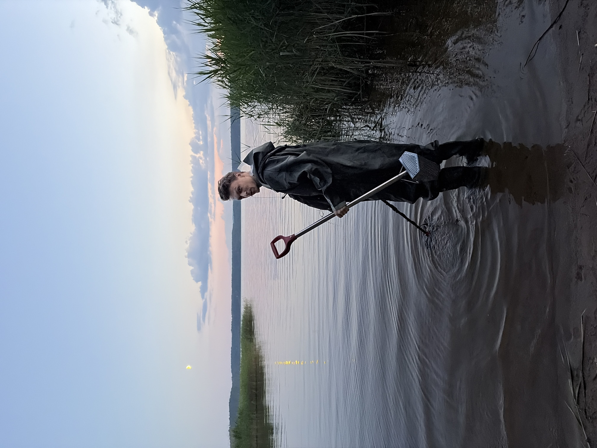 Evening metal detecting session at a lakeside camp