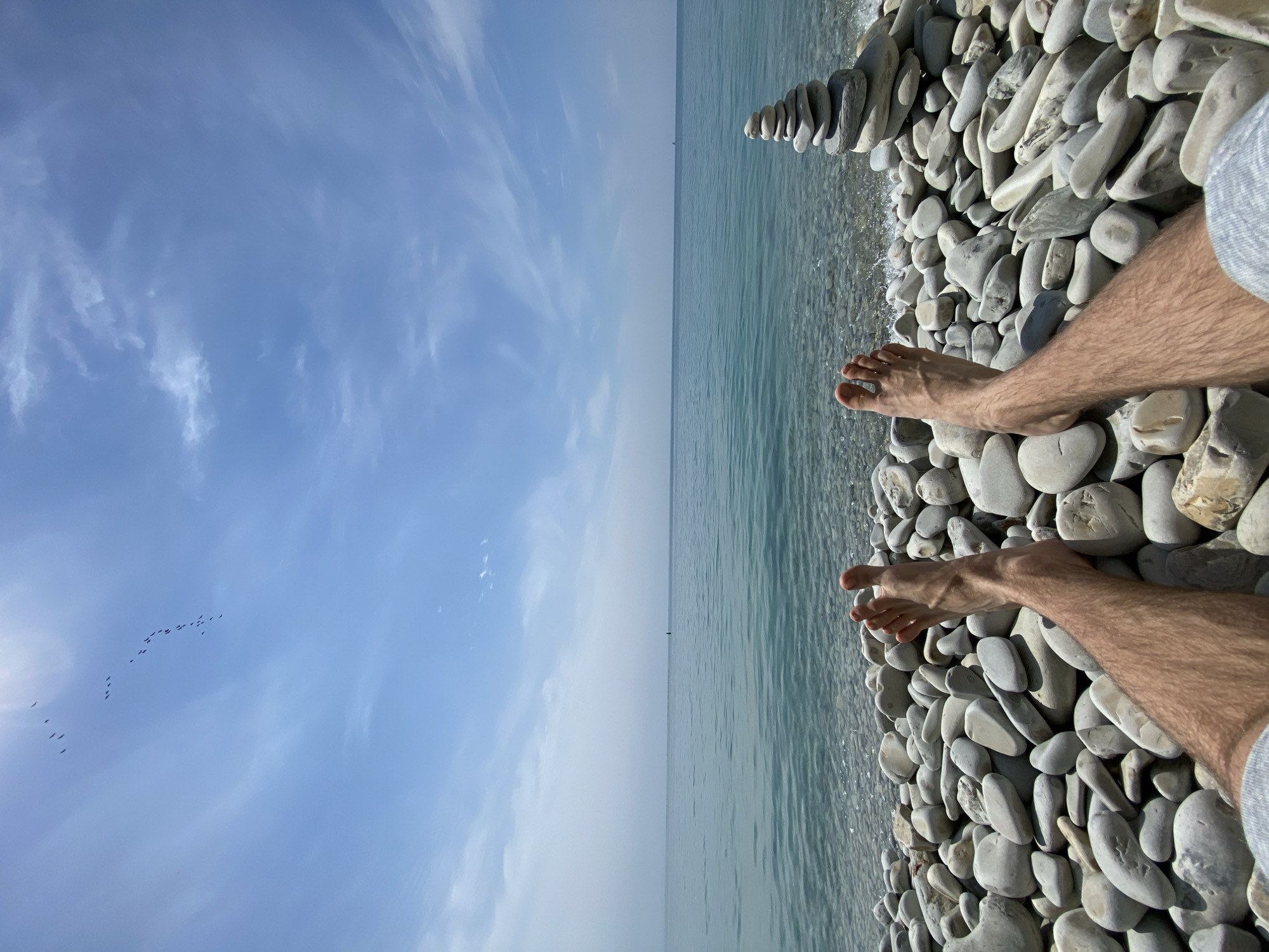 Beachgoer relaxes on pebble shore in Gelendzhik, Russia