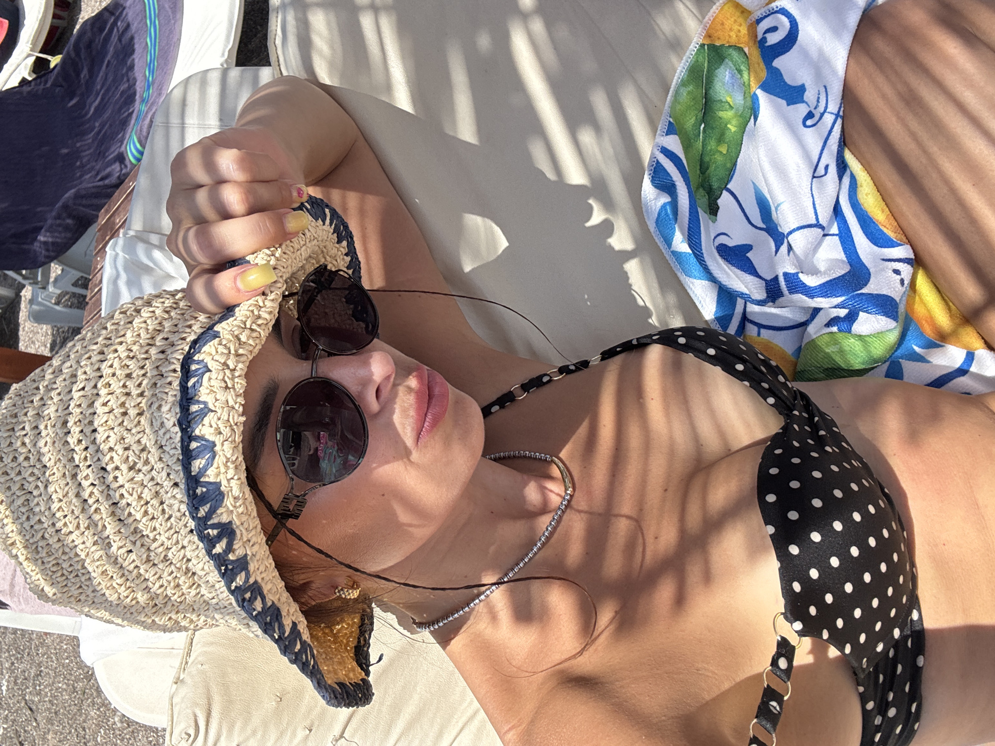 Lazy beach afternoon: sun, straw hats, and a paraglide