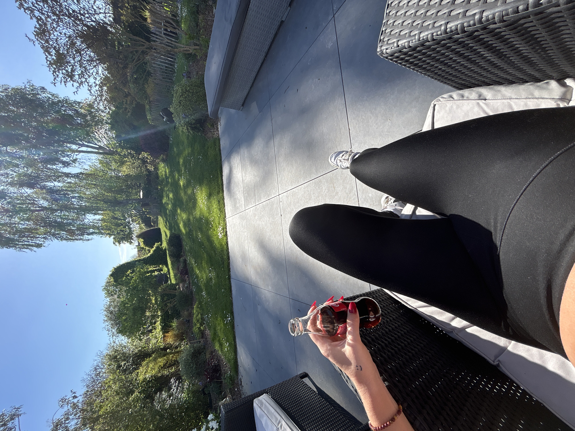 Woman relaxes with phone, dog in French garden