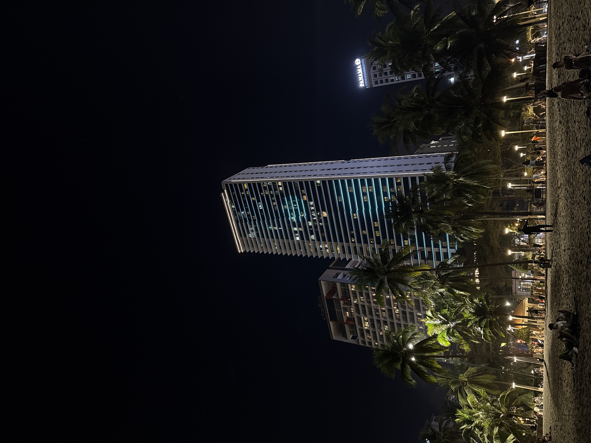 Street musician performs near Nha Trang skyscrapers under full moon