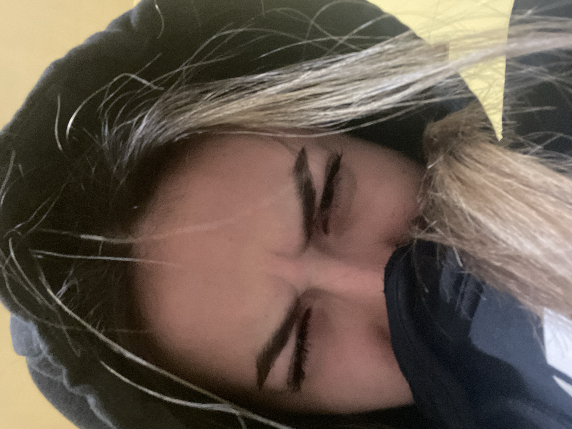 Person in black hoodie photographed with eyes closed in Kavarna