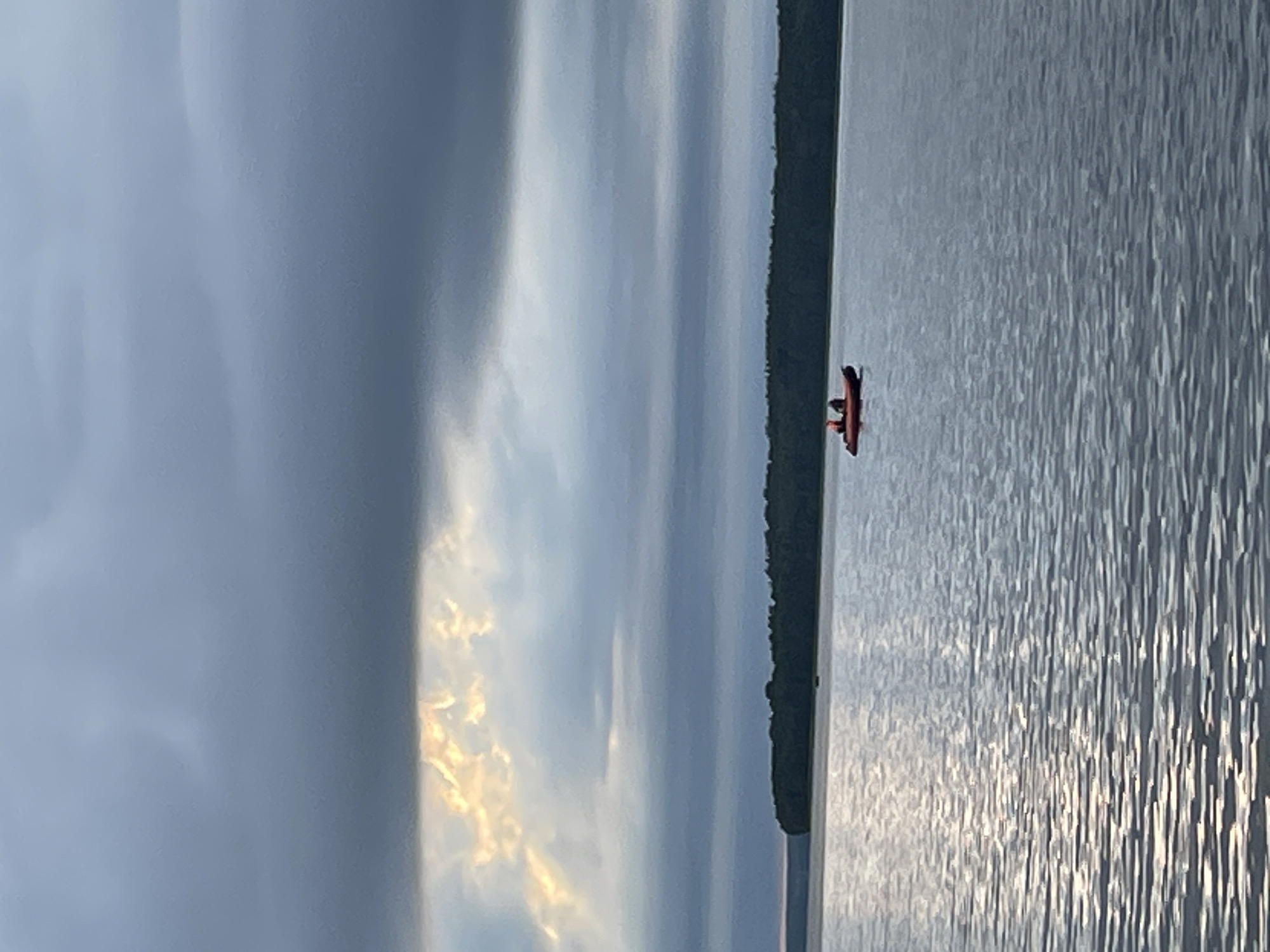 Orange inflatable boat on a moody Russian lake under stormy skies