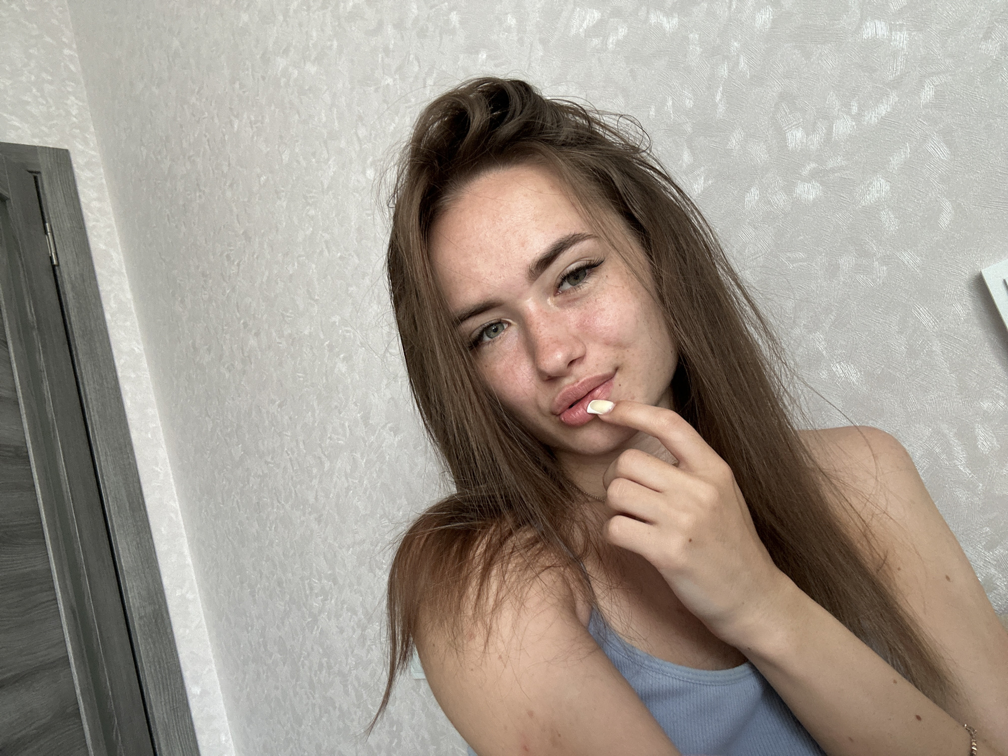 Woman Takes Series of Selfies in Light Blue Tank Top