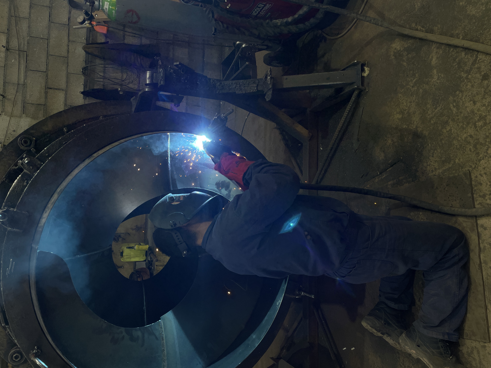 Welder works inside metal structure in Tomba, Montenegro