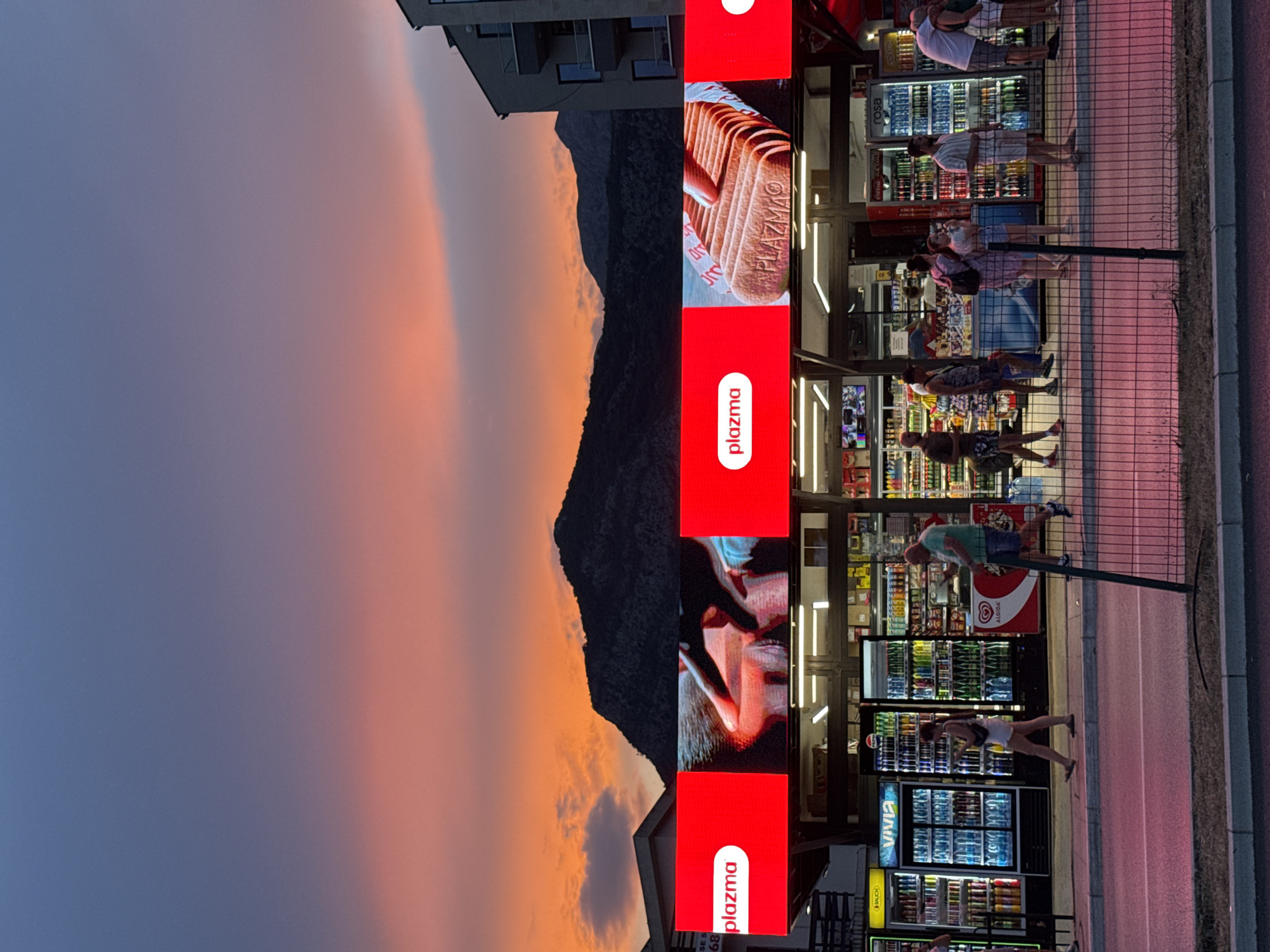 Dusk stroll past palms, storefronts, and a curved glass tower