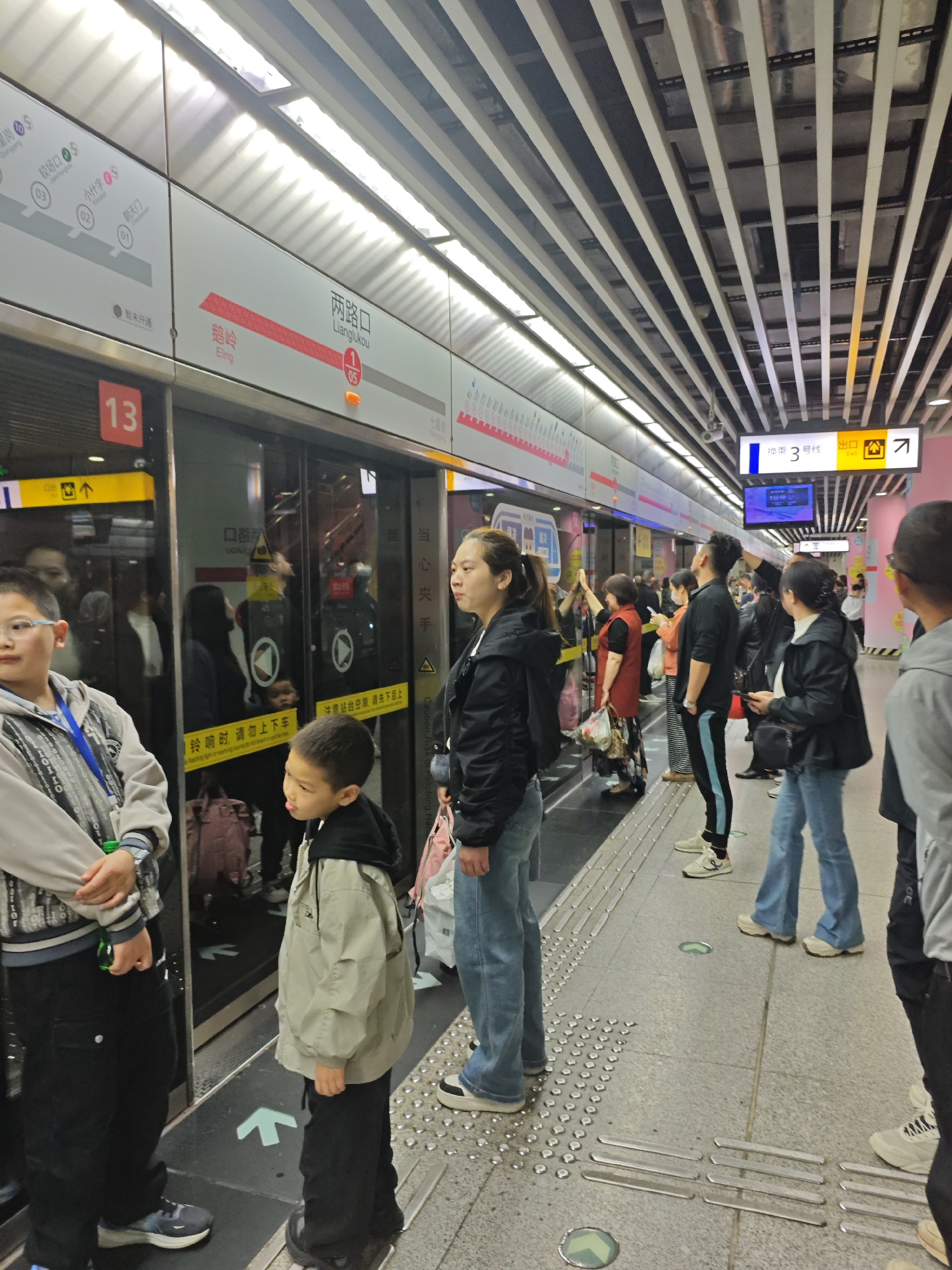 Late-night commuters wait at Lianglukou subway station in Yuzhong