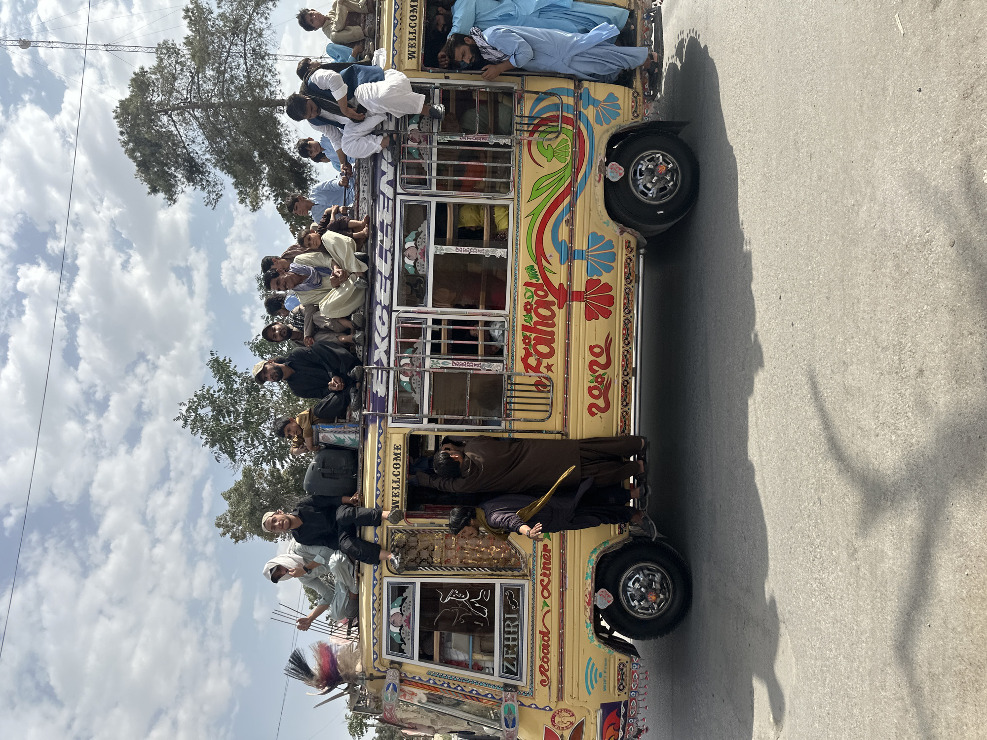 Ornately painted overloaded bus rolling down a rural road