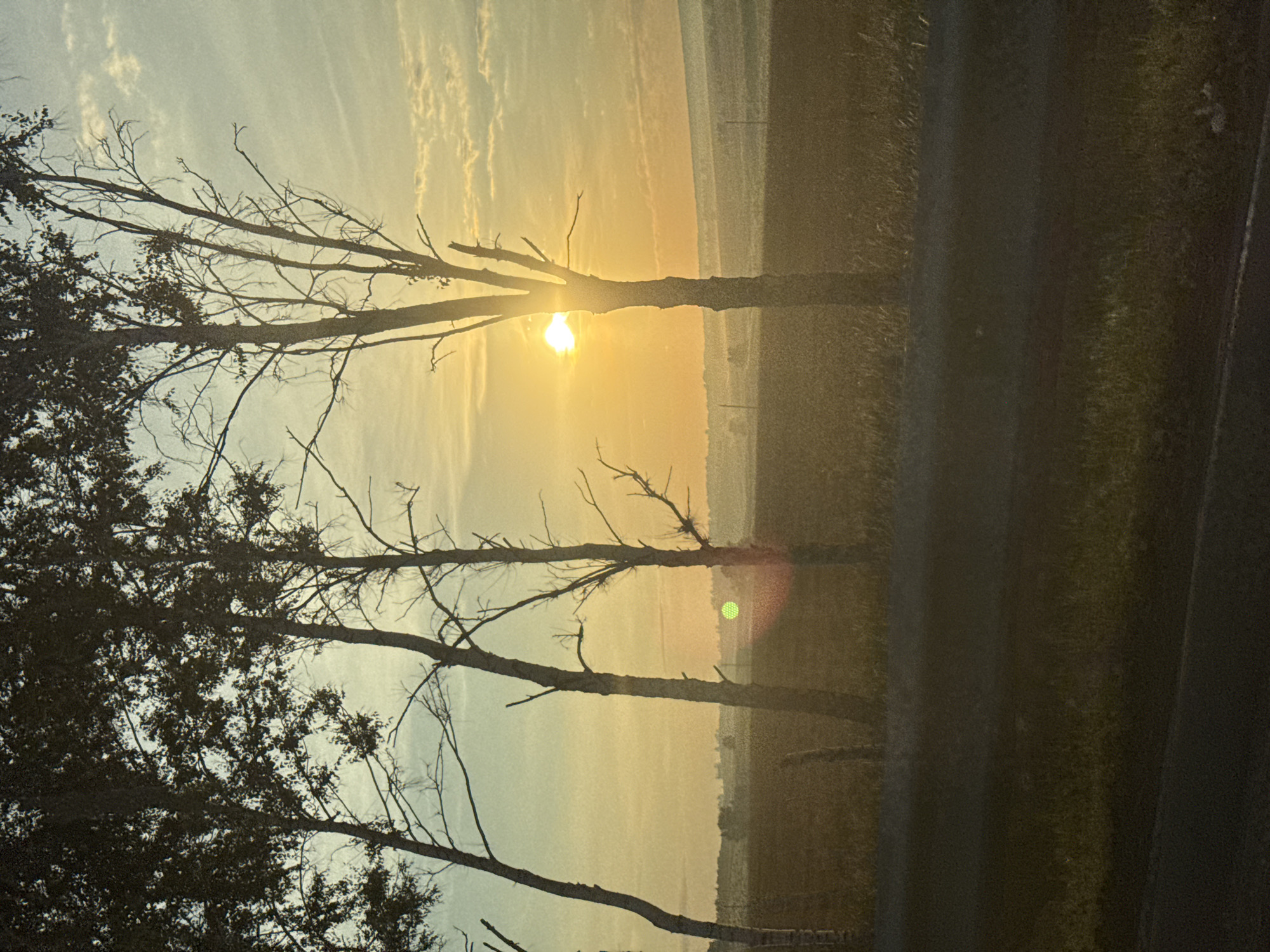 Sunrise breaks over a silhouetted rural landscape in Russia