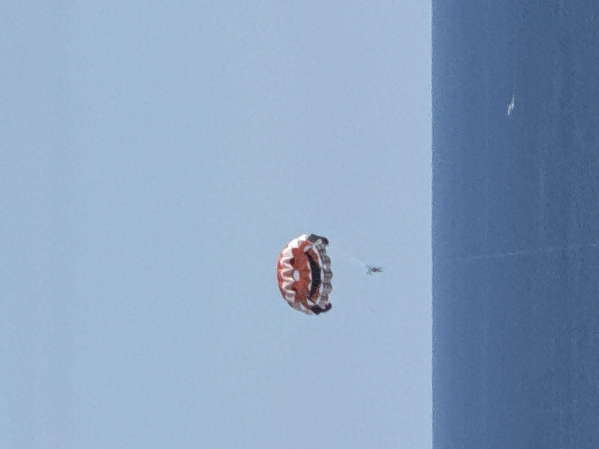 Smiley-face parasail over Montenegrin coast, mountains behind
