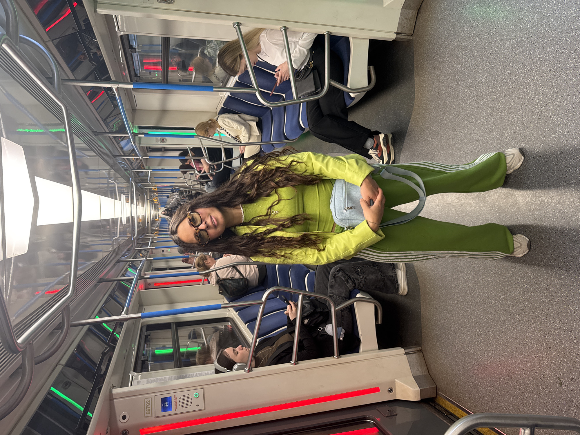 Woman in green tracksuit rides Kazan subway during morning commute