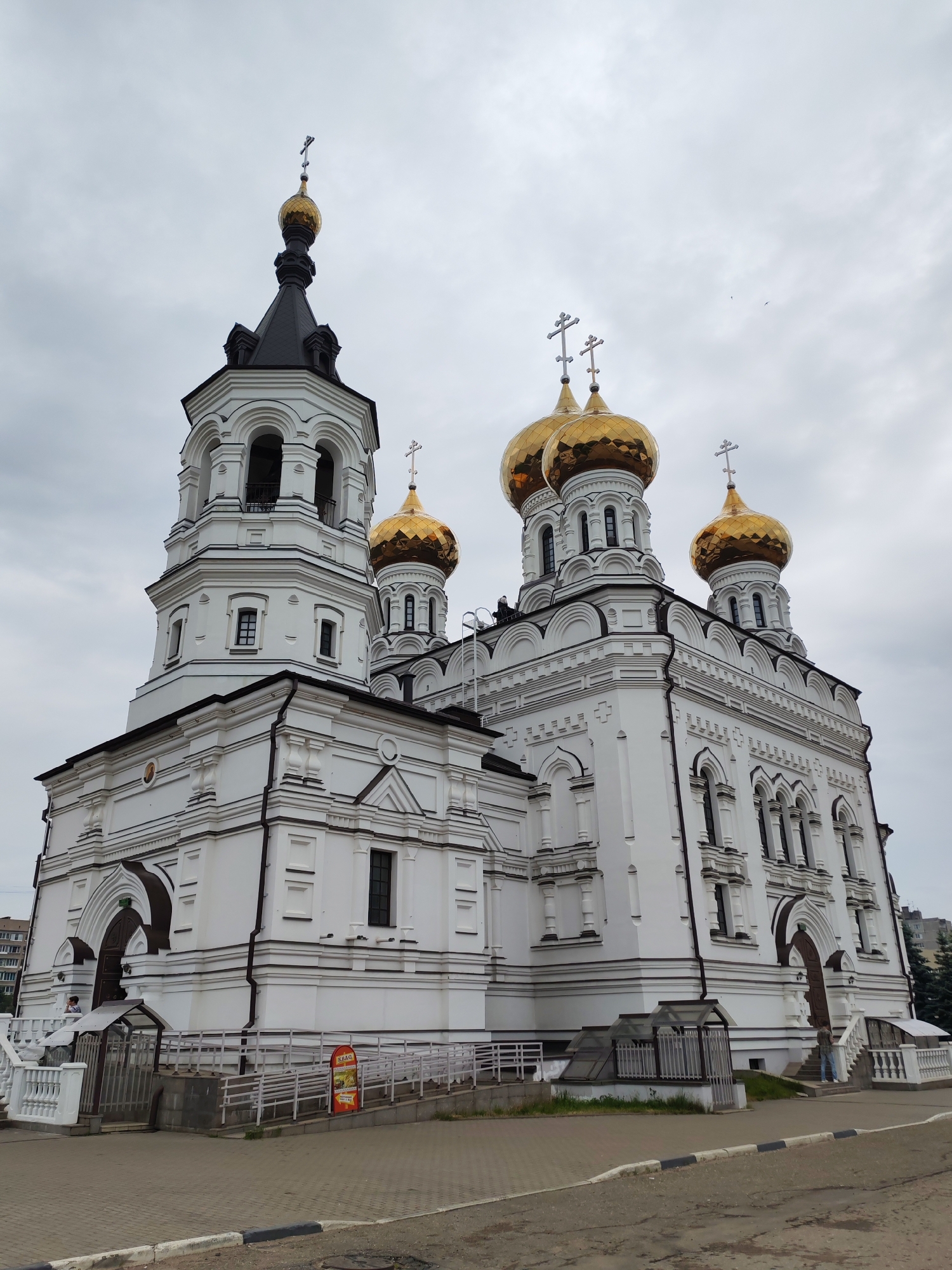 Tourist photographs Ascension Cathedral in Tver on overcast morning