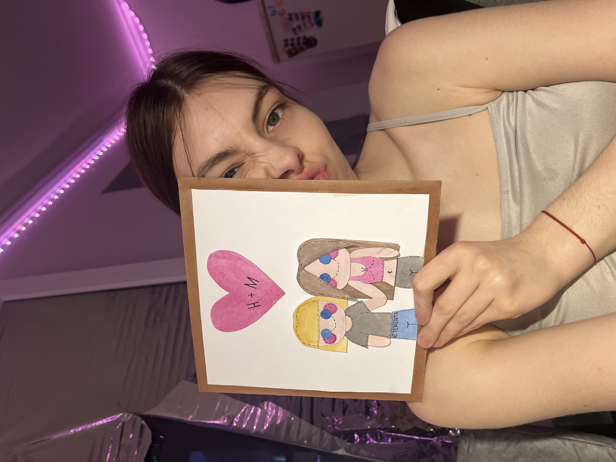 Woman displays handmade artwork featuring two figures in Saint Petersburg
