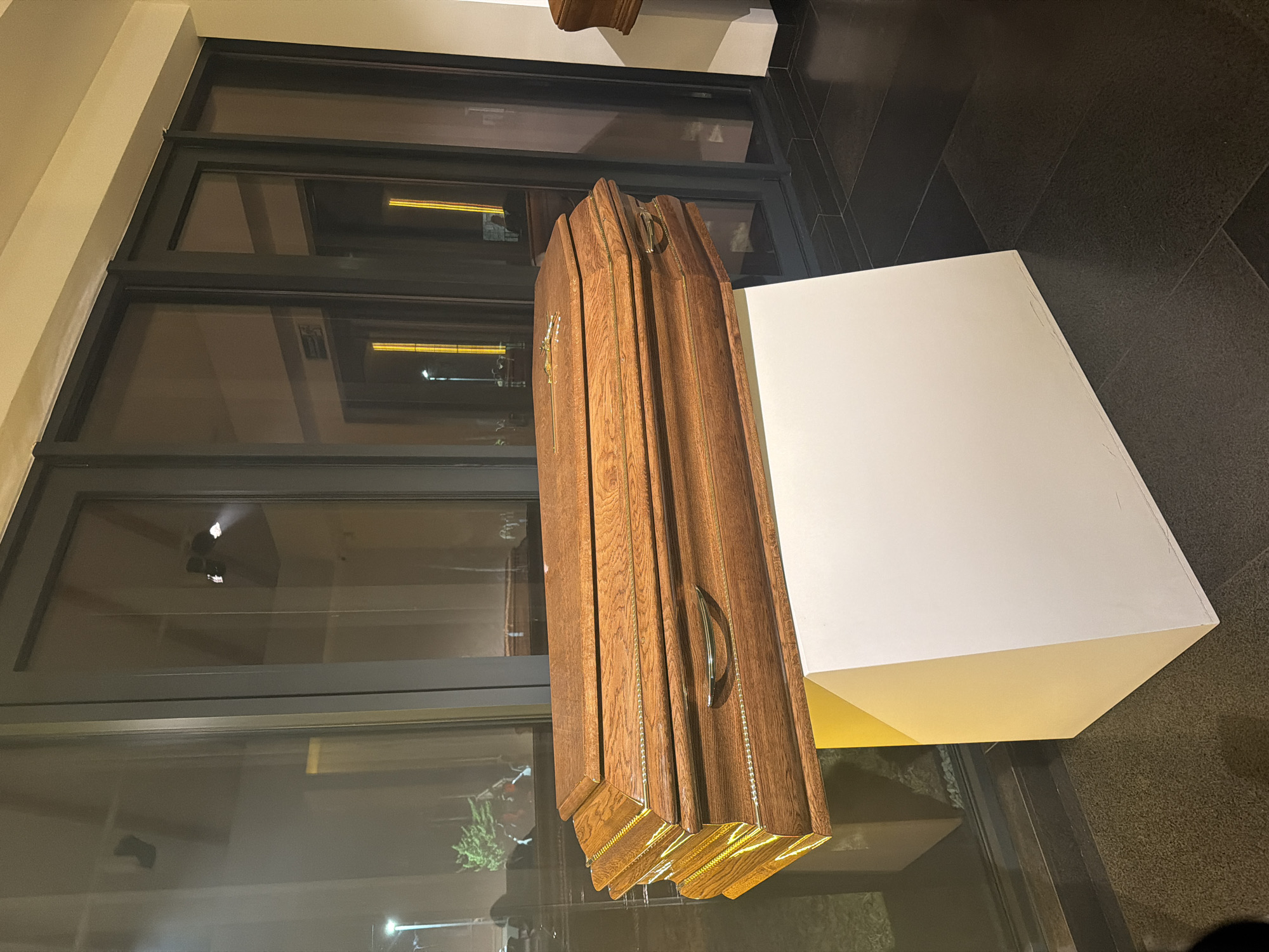 Funeral home displays coffins and urns witnessed by observers