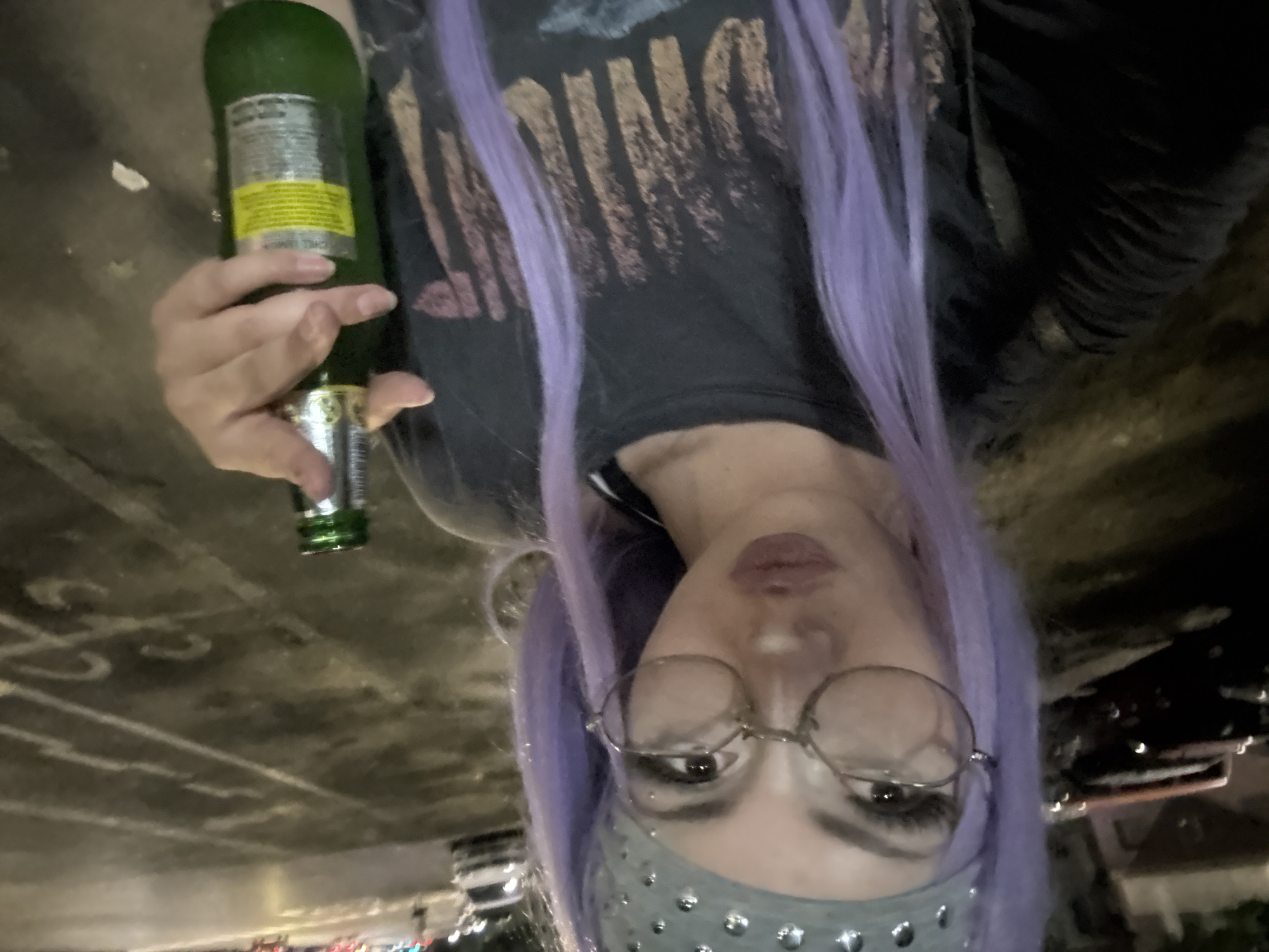 Purple-haired figure with green beer bottle, Milan night out