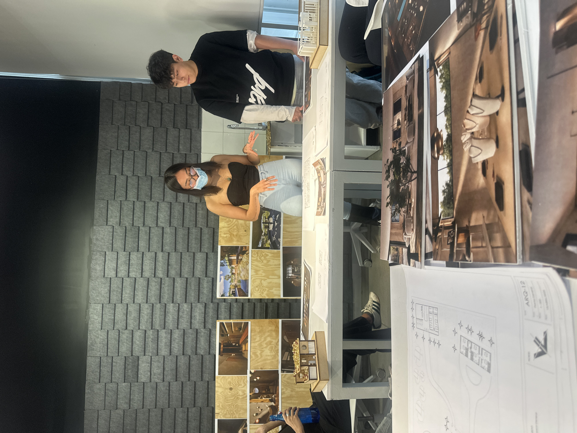 Two people review architectural plans in Mexico City workspace