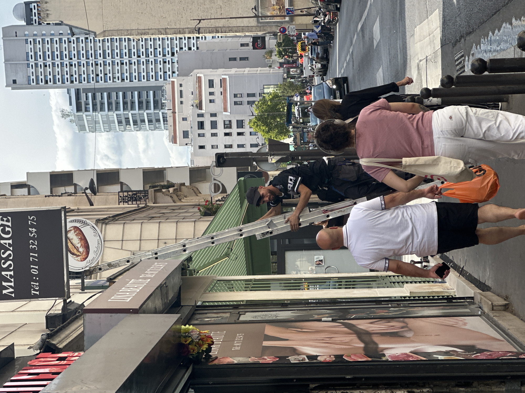 Cat on a balcony, Parisian streets below, July afternoon