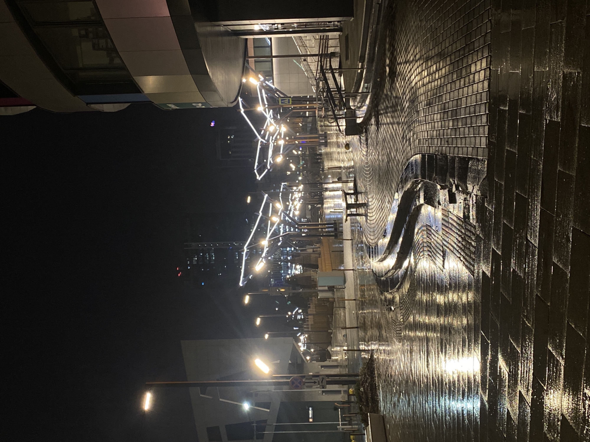 Wet night street scene with decorative lights in Yekaterinburg