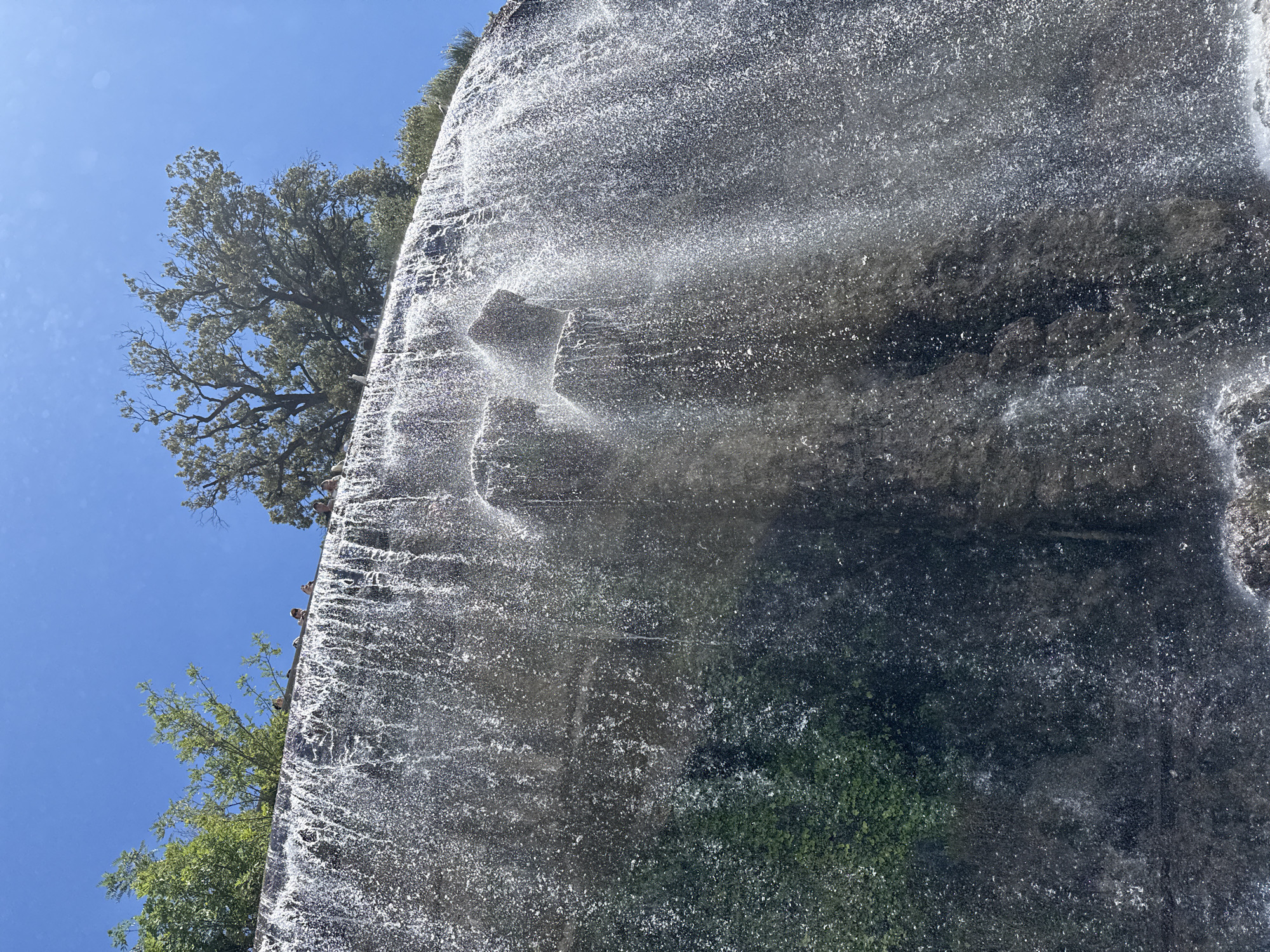 Waterfall observed at rocky cliff face with clear skies