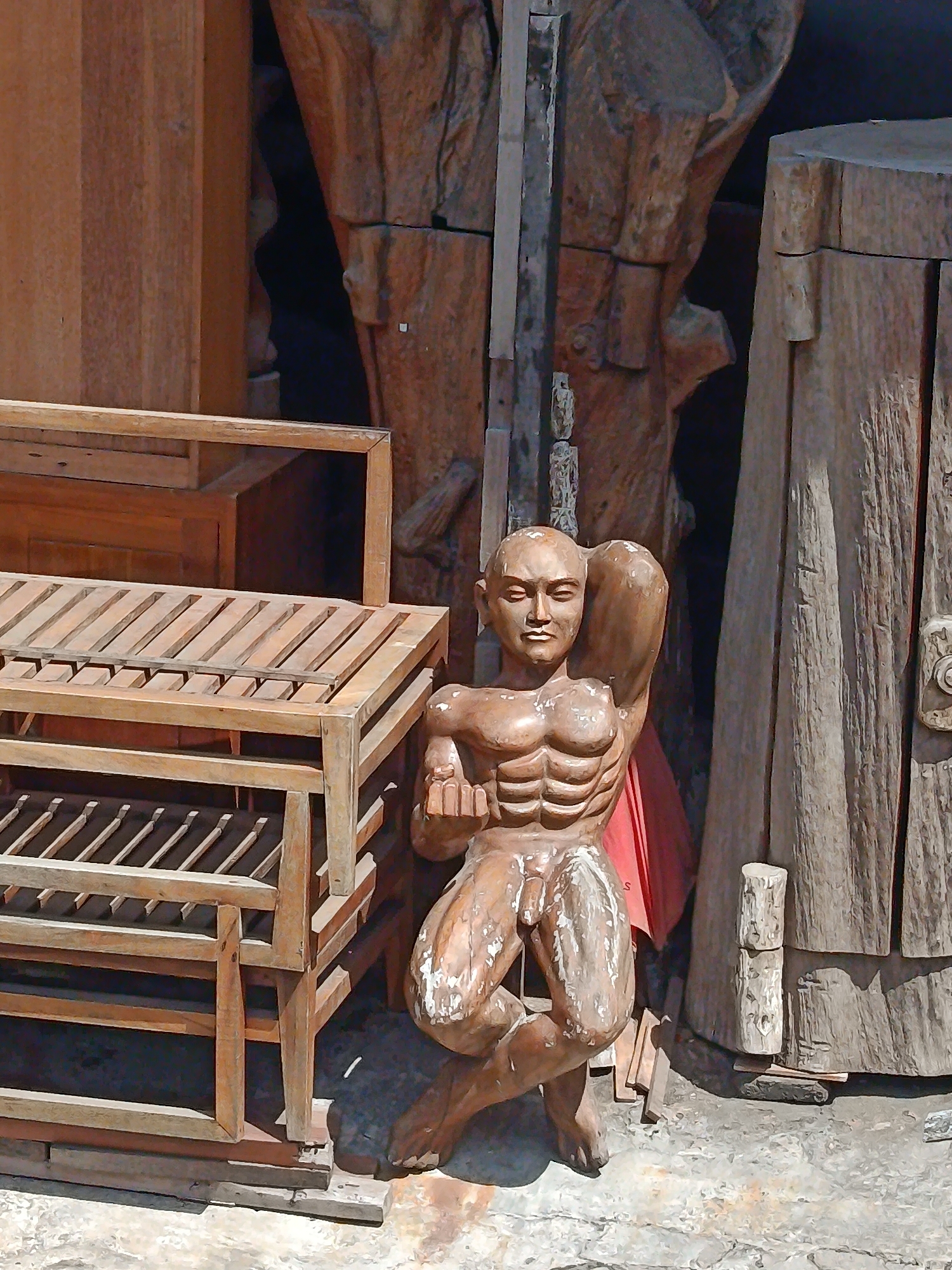 Carved wooden sculptures and furniture fill a Kuta workshop