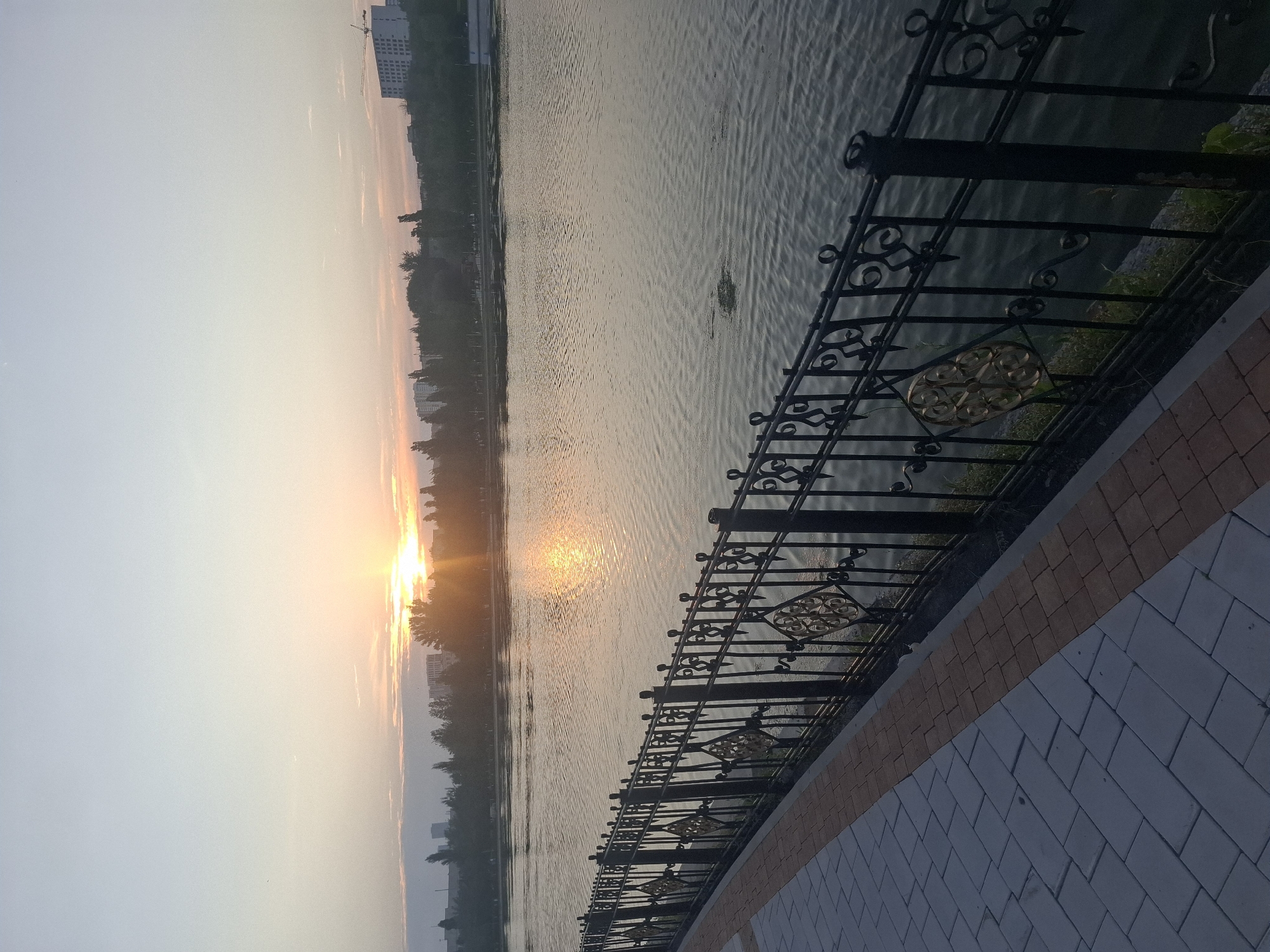 Golden light and calm water along Astana's lakeside promenade