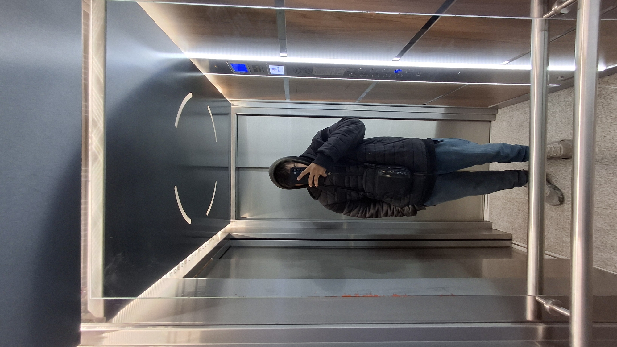 Person photographs self in elevator door reflection