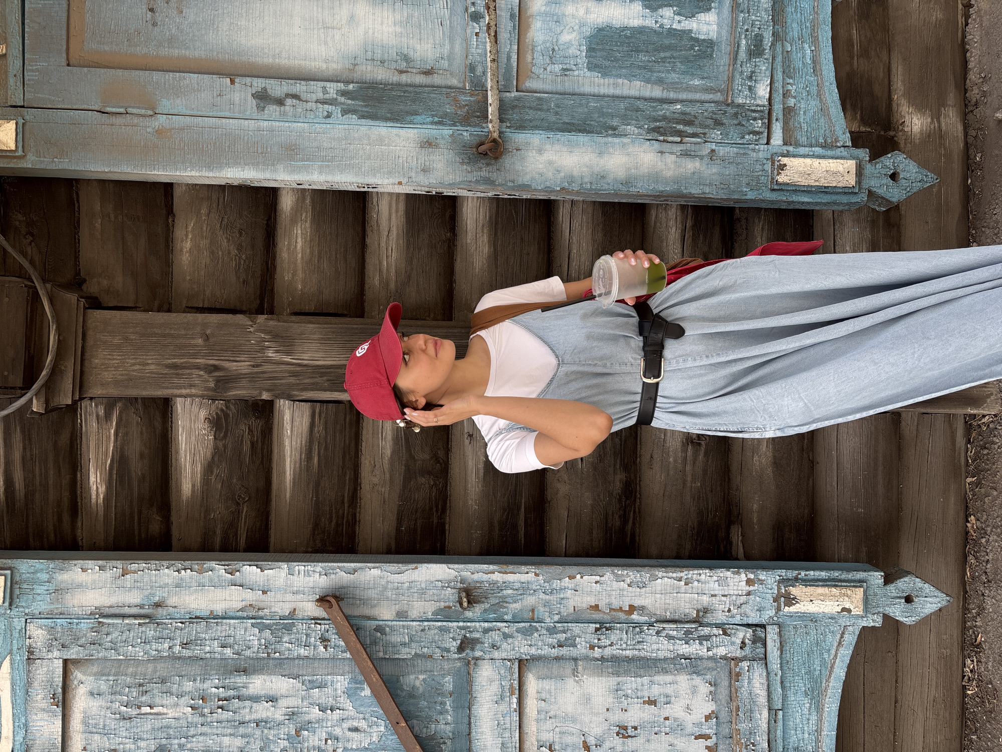 Woman in red cap photographed at wooden building in Krasnoyarsk